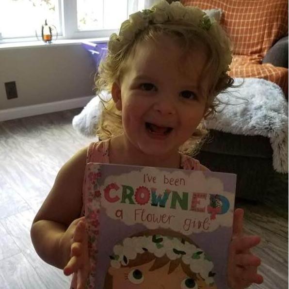 Our little flower girl loves her crown and book