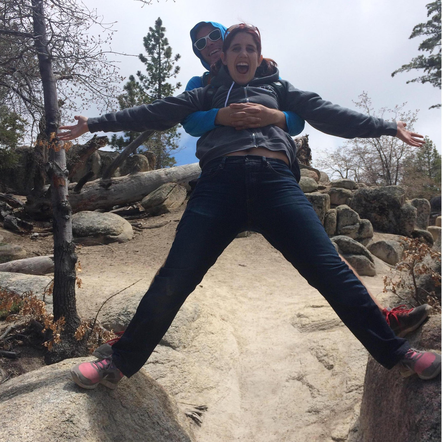 Straddling two rocks. The look on Karly's face is not a giant goofy smile. She is screaming. Jackson is laughing at her. Classic.