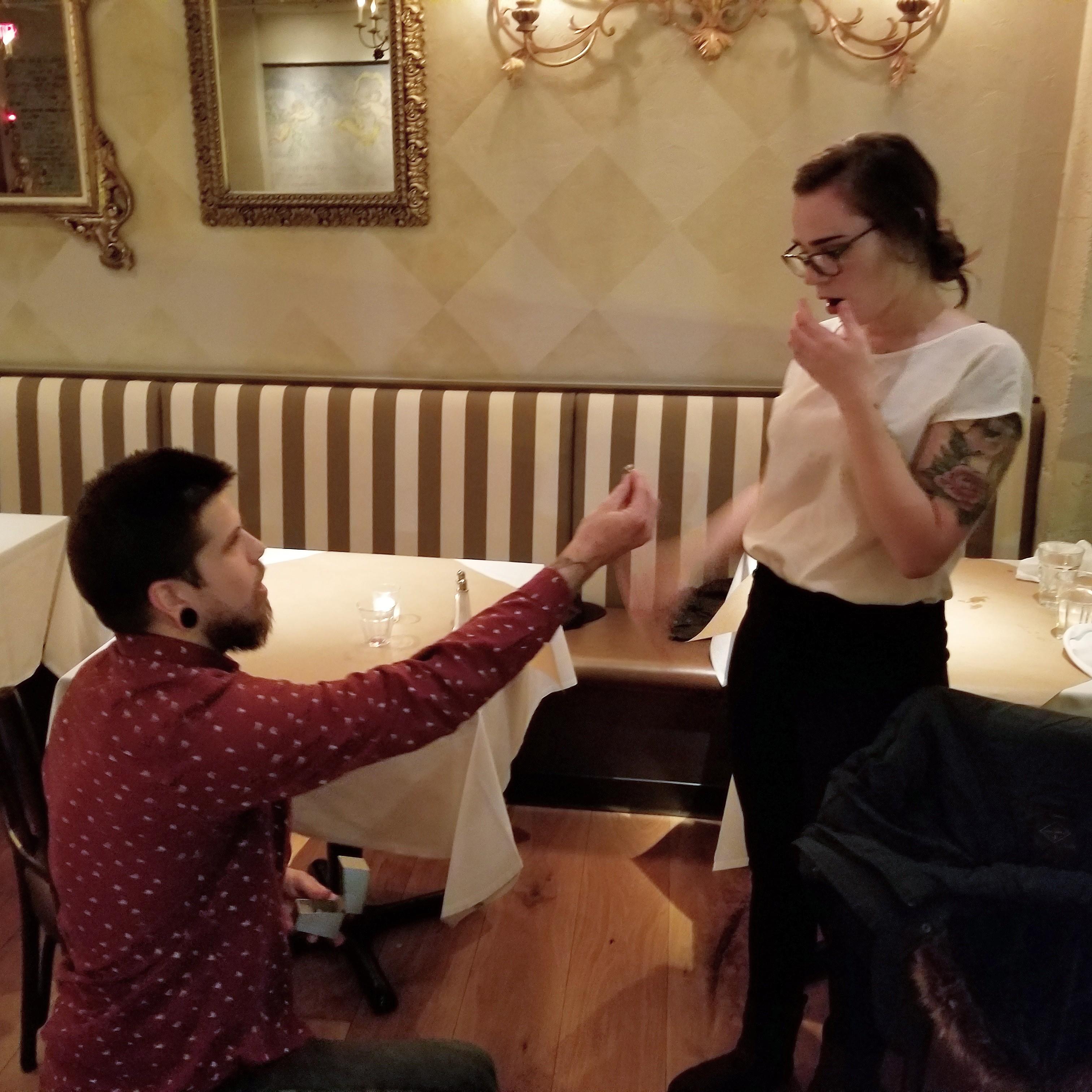 Shelby proposed at The Pink Door in Seattle on their seventh anniversary. He was trying to get the farris wheel in the background, but he moved too fast for the waitress to capture it in the moment.