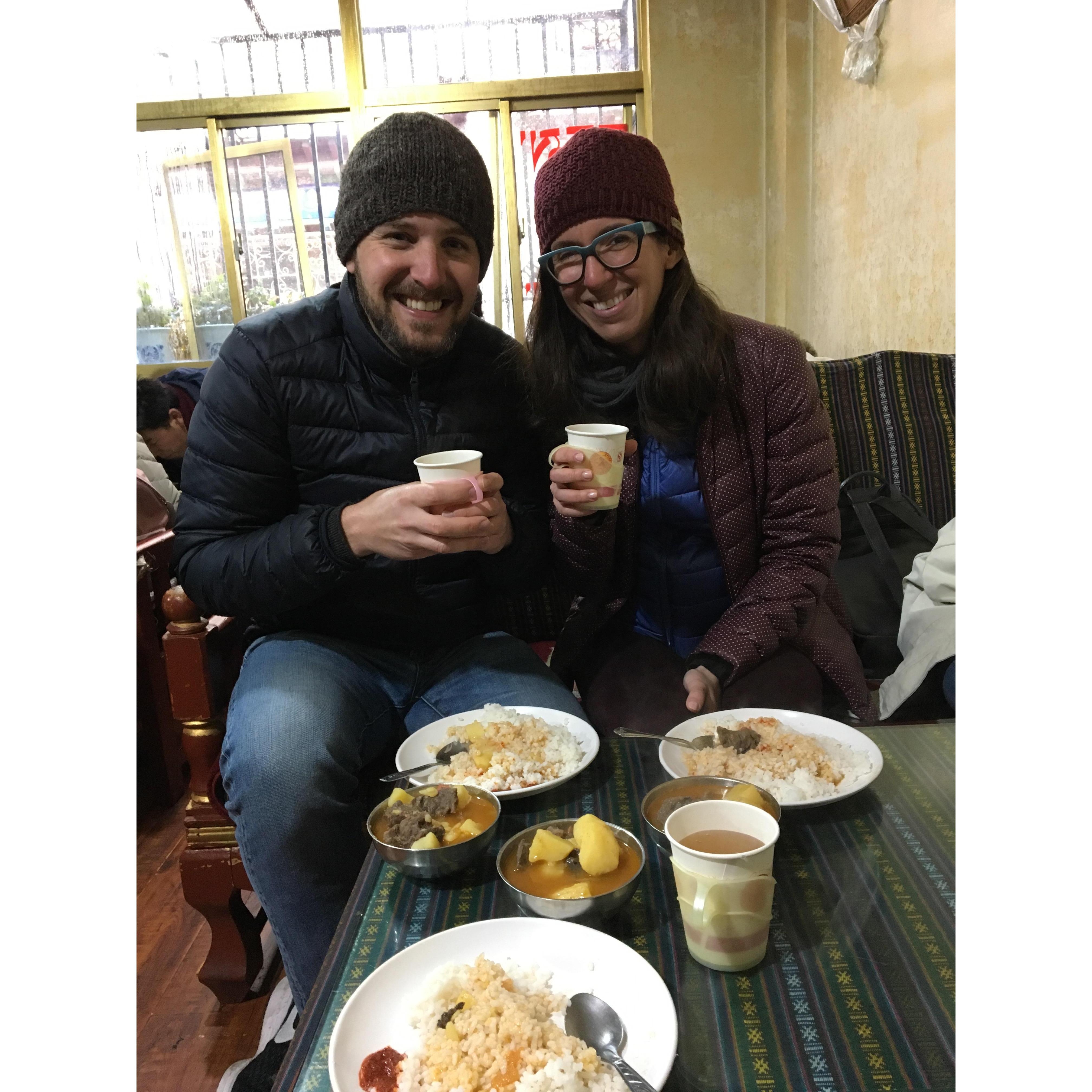 Sharing a meal with local Tibetans in a stranger's living room. Erica asks that you don't tell her mom she went into a stranger's house.