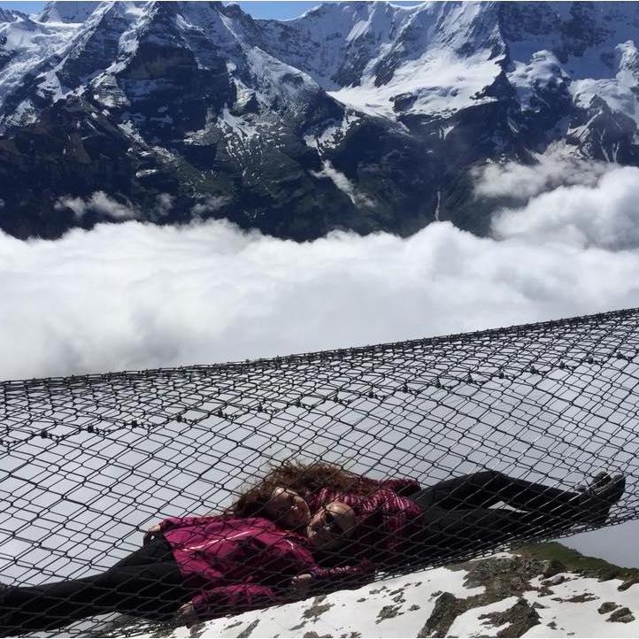 A couple suspended a few thousand feet up by a net together, stays together.