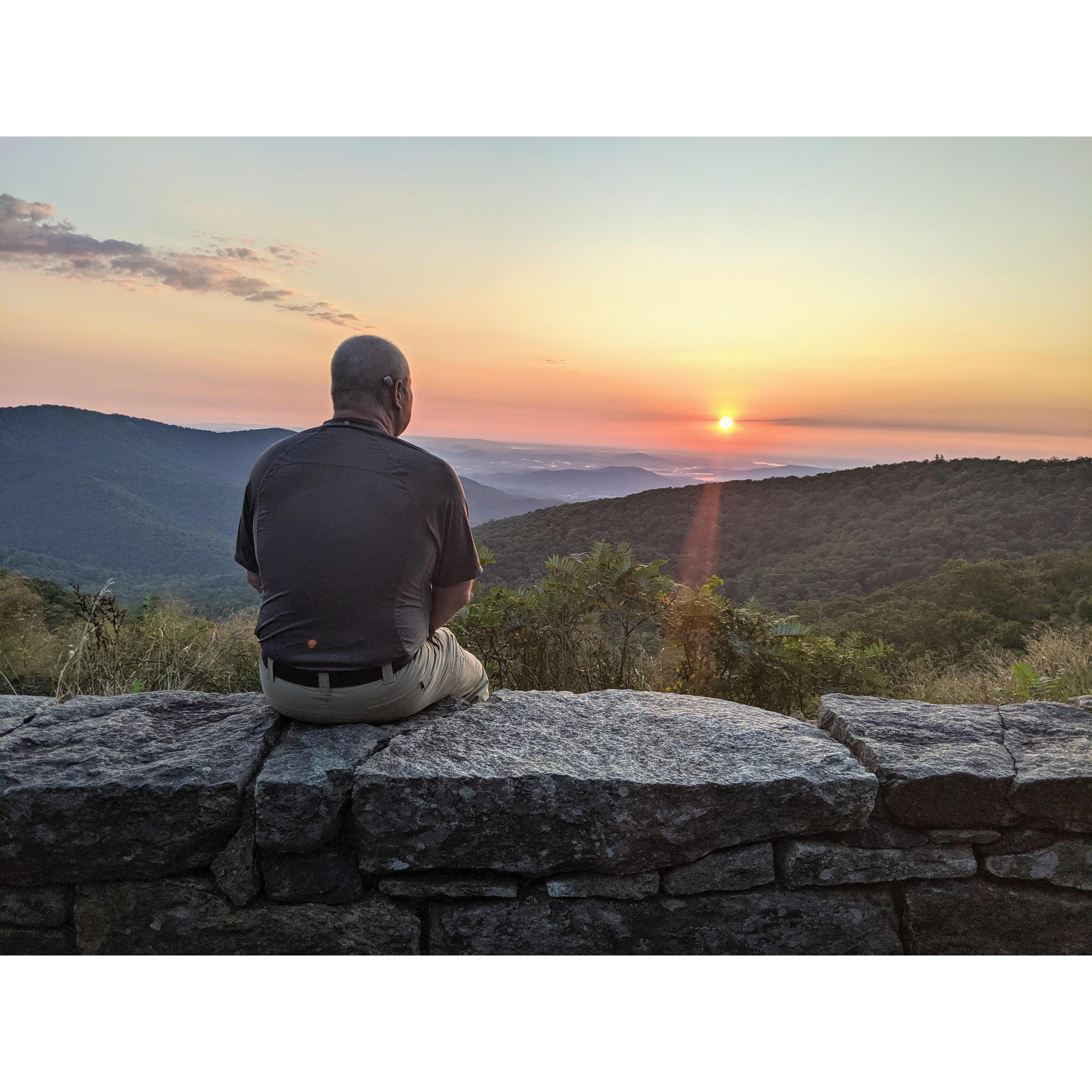 Jim taking a brief break while taking photos of the sunrise on the morning of Monica's birthday in Shenandoah in 2019.