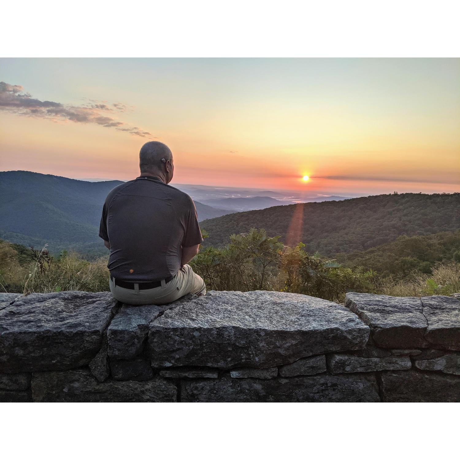Jim taking a brief break while taking photos of the sunrise on the morning of Monica's birthday in Shenandoah in 2019.