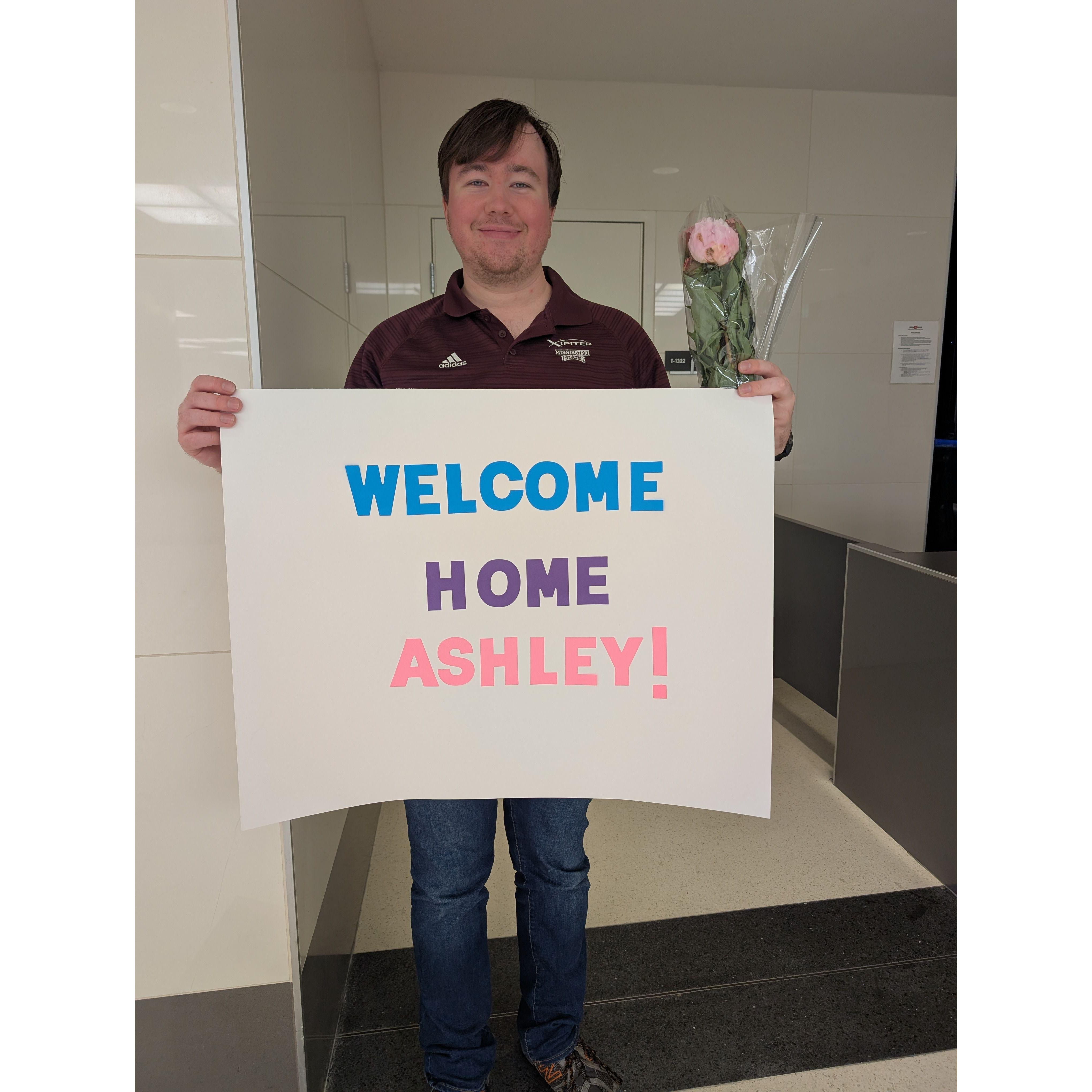 Matthew brought a sign and flowers to the airport to welcome Ashley home after traveling for 2 weeks. If he looks sleepy, it's because Ashley's flight was delayed, and it was past his bedtime!