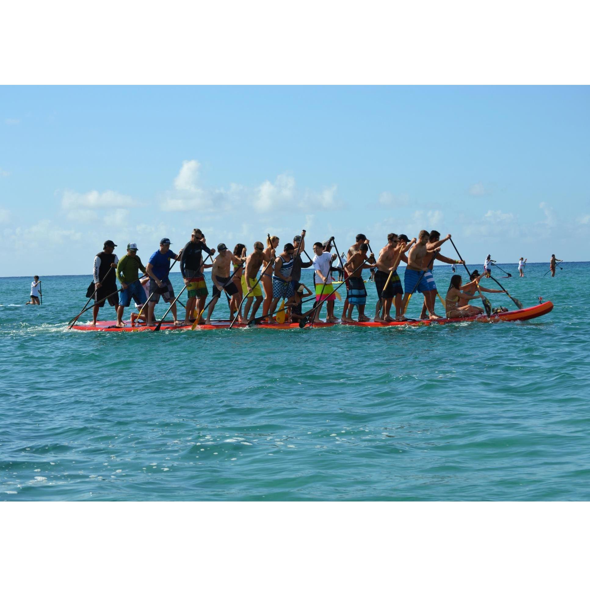 Evan, Amber and Jeff making history with 30+ people paddling one giant stand up paddle board (known as SUPzilla) in a race to support skin cancer.