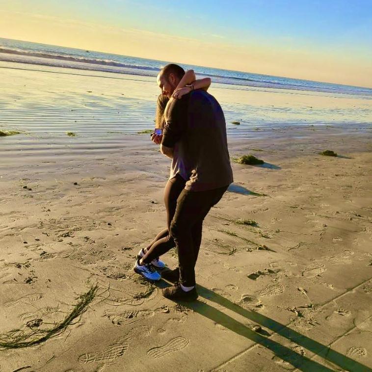 Completely unexpected proposal. He challenged Kaila to a race on the beach. When they took off Morgann faked an injury. Kaila came back to check on him and he turned around on one knee with the ring.