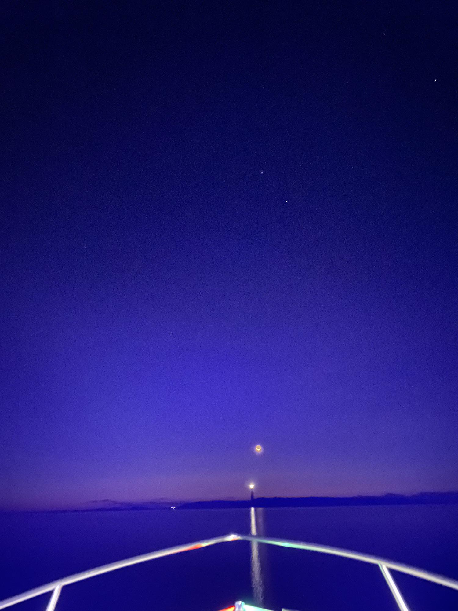 Pitch black 5am boat ride to the island to see the sunrise! Note the moon and light coming around on the light house *just* as I snapped this photo! 09/05/2021