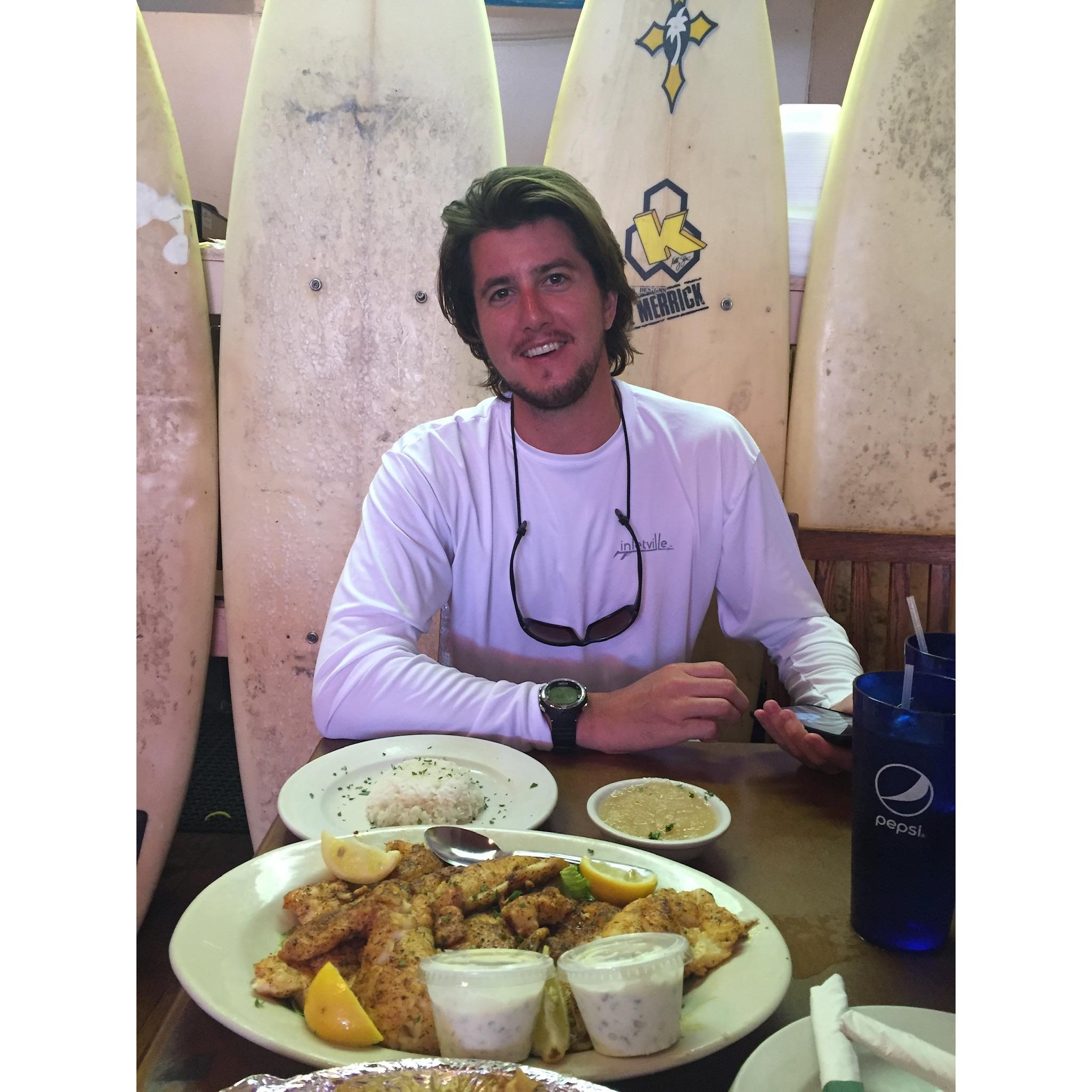 A sunburnt Adam enjoying some fresh fish