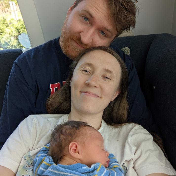 New family snuggling on the couch together.