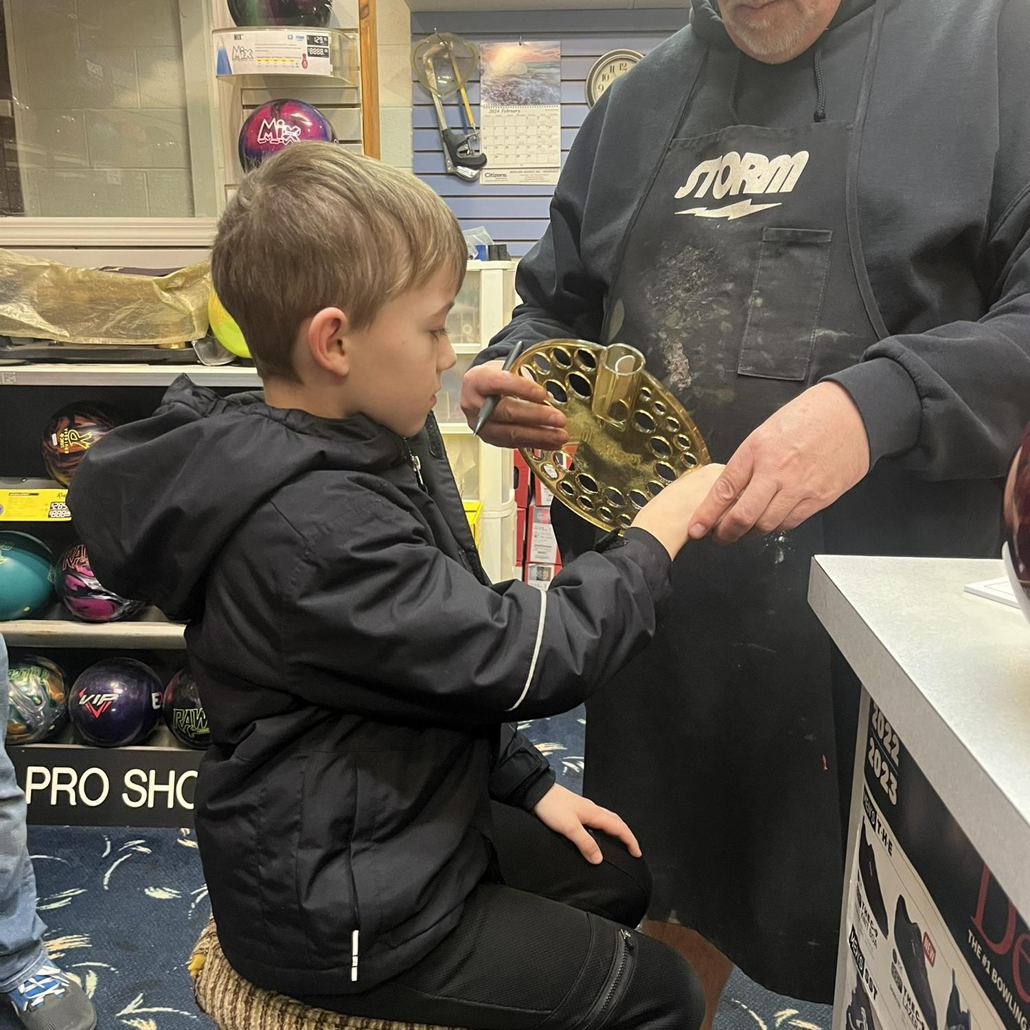 Getting fitted for his bowling ball