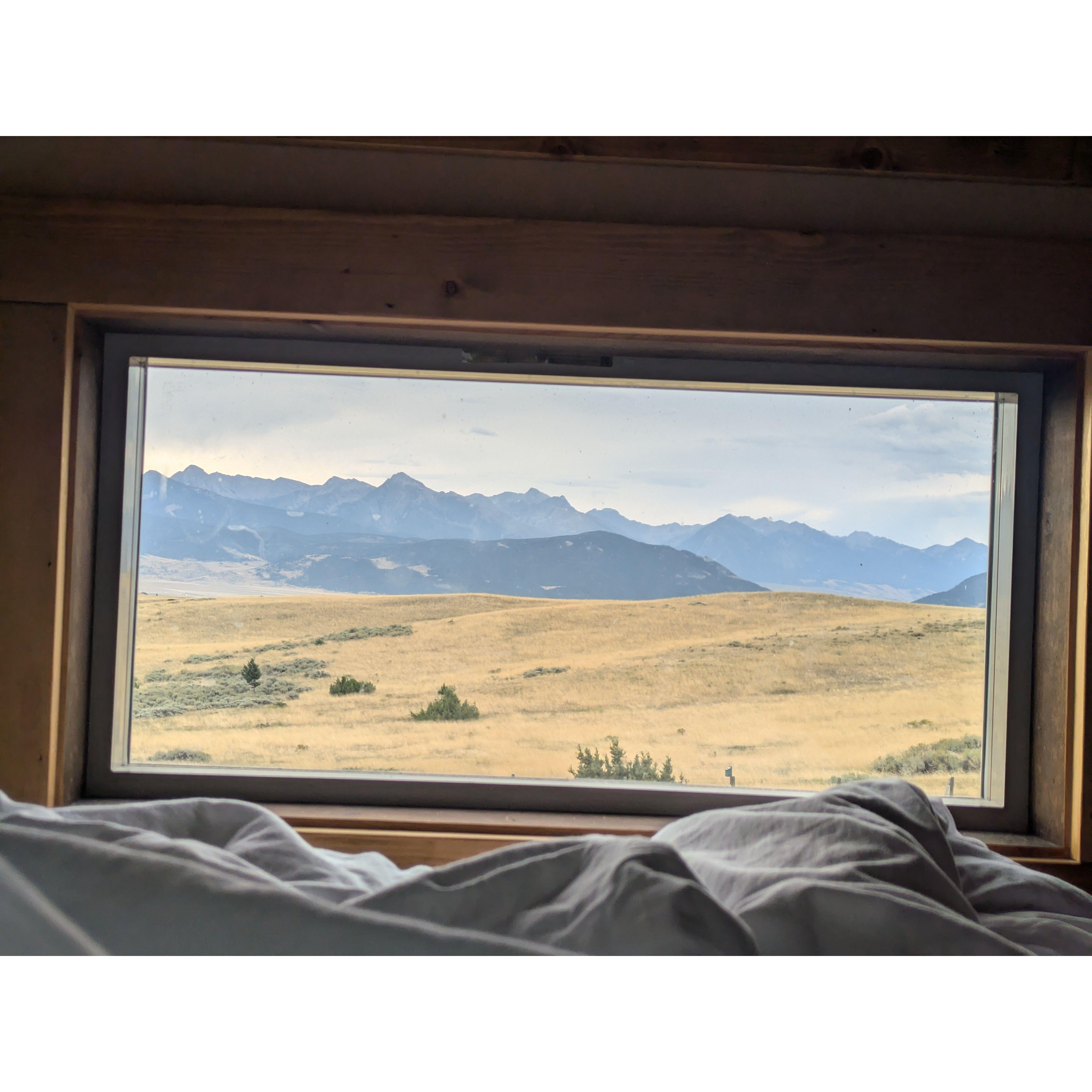 This is the morning view out our traincar tiny house loft bed window to the mountains of Montana in 2024.