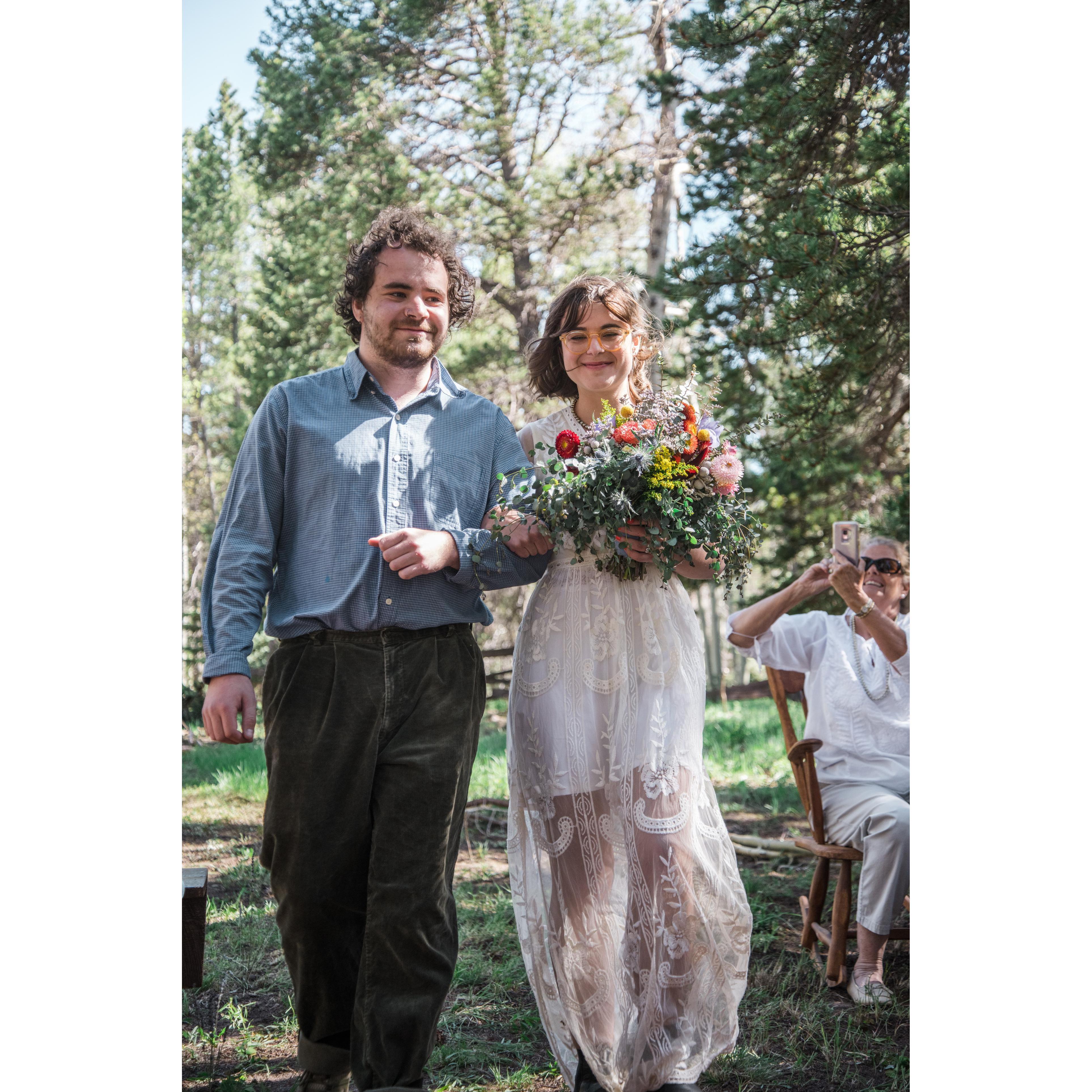 Abby walks down the aisle, escorted by her brother Ben.