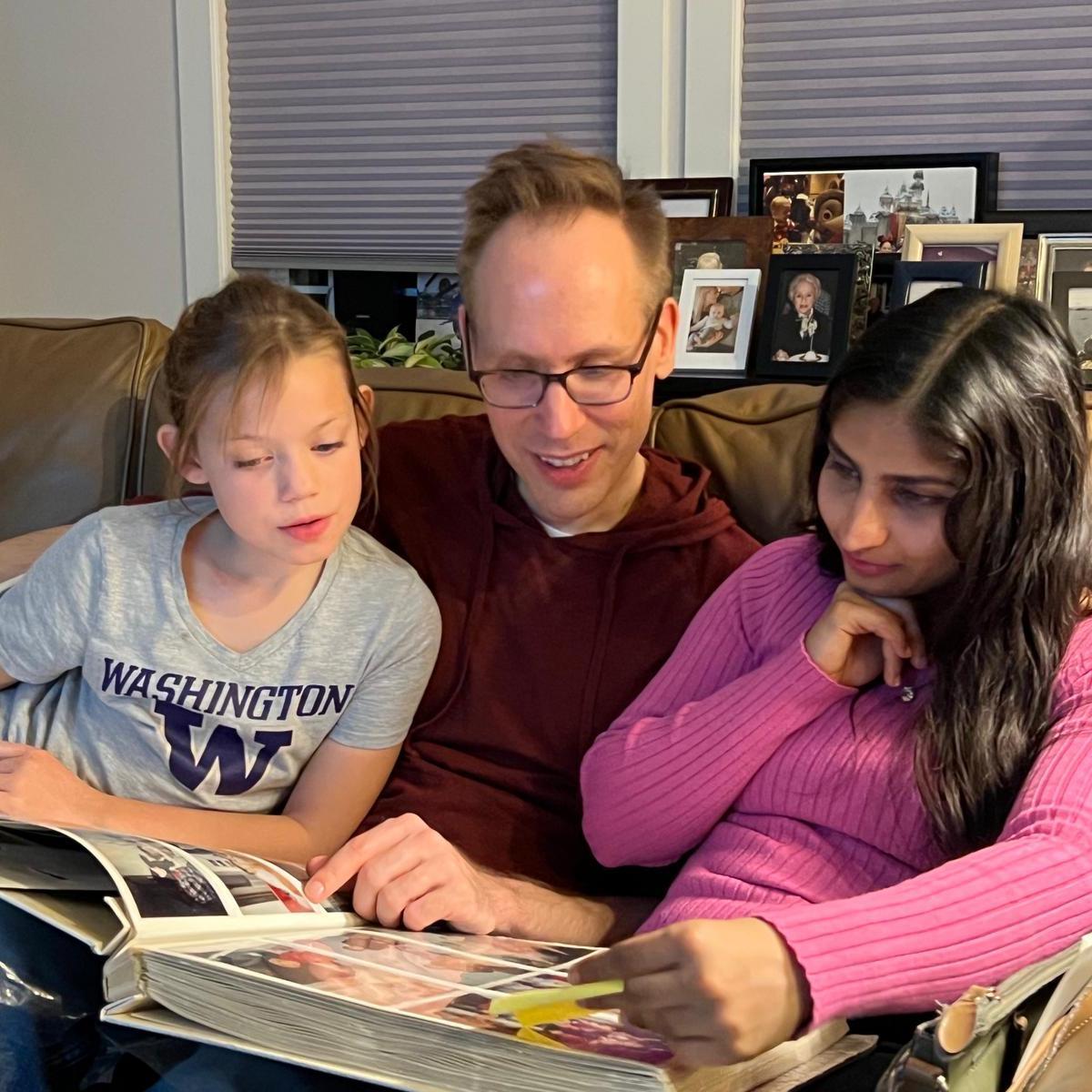 Troy showing Mackenzie and Aarica photo albums from his childhood