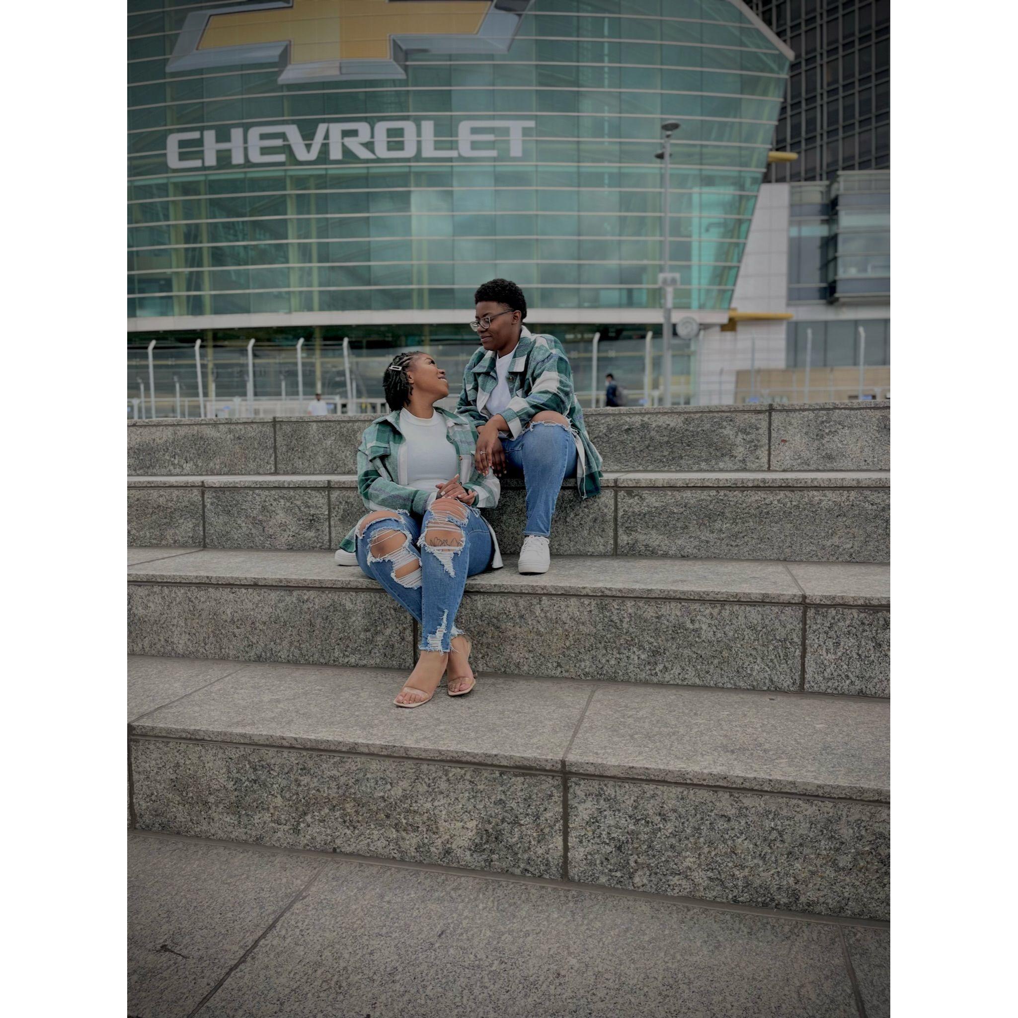 On the steps of the Riverwalk, along the Detroit River, overlooking the border of Canada.