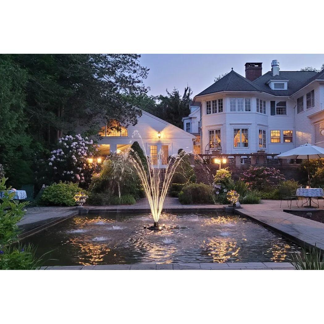 At night, the fountain at the Harding Allen Estate transforms into an ethereal spectacle, its waters shimmering under the moonlight, casting a serene glow across the quiet elegance of the surrounding gardens.
