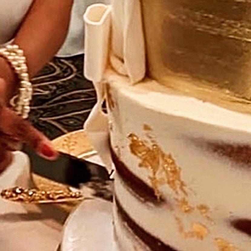 Triple-tiered, four-layer vanilla cake with edible gold icing and mango curd & cream cheese swirl filling by Tasty Bakery