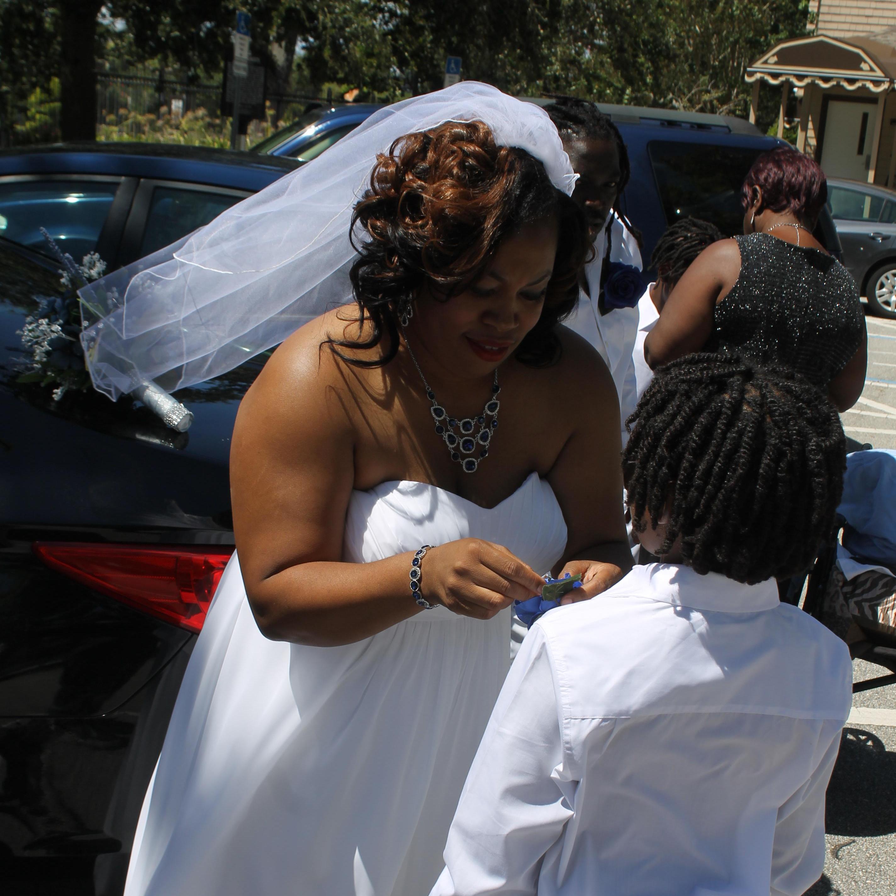 The Bride adjusting the flower on the ring bearer lapel. Trying not to poke him with the needle.