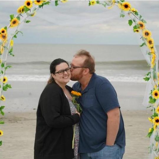 Engagement picture. Josh put together a beautiful archway AND runway of sunflowers.