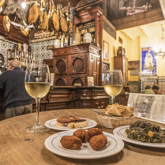 Treat us to tapas and Spanish wine in Seville!