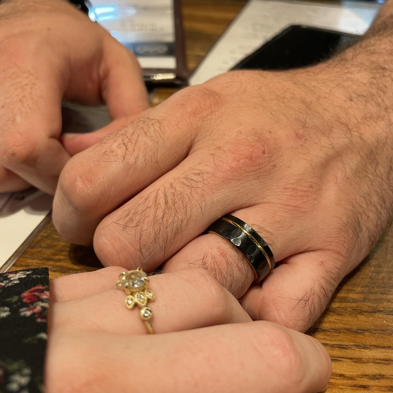 Admiring our engagement rings at our celebration dinner.