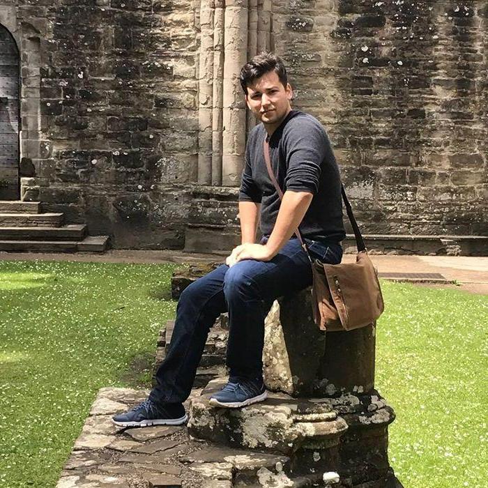 Robert poses on a decayed column in Tintern Abbey; 2017.