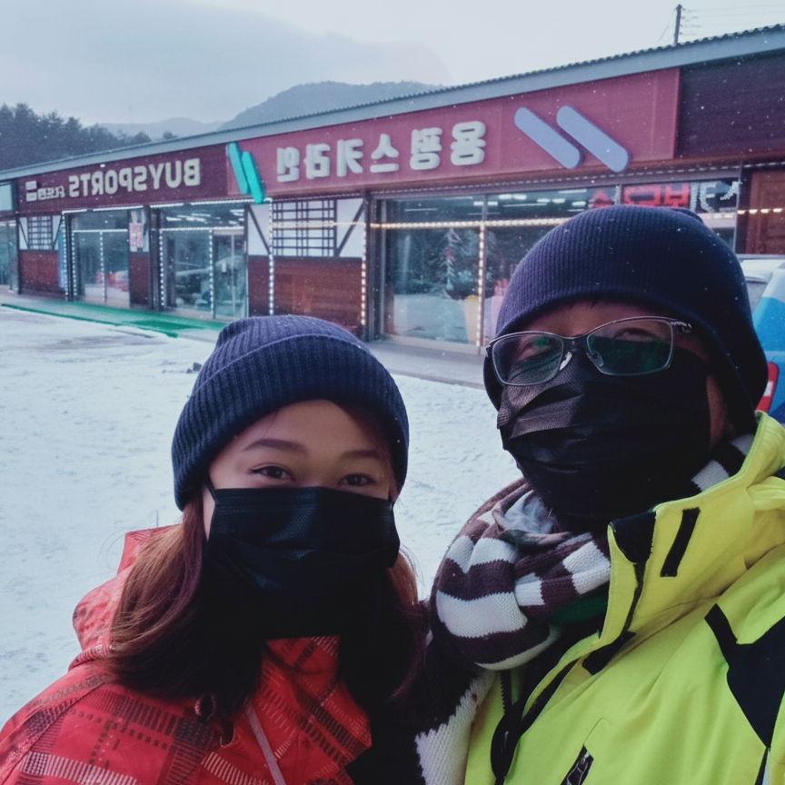Enjoying our first ever snowfall outside a ski rental shop at Yongpyong in South Korea.