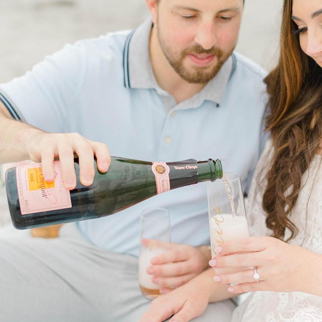 We love to share a bottle of wine or champagne and decided to bring one of our favorites to enjoy on the beach for our engagement photos. We can't wait to cheers with you at the wedding!