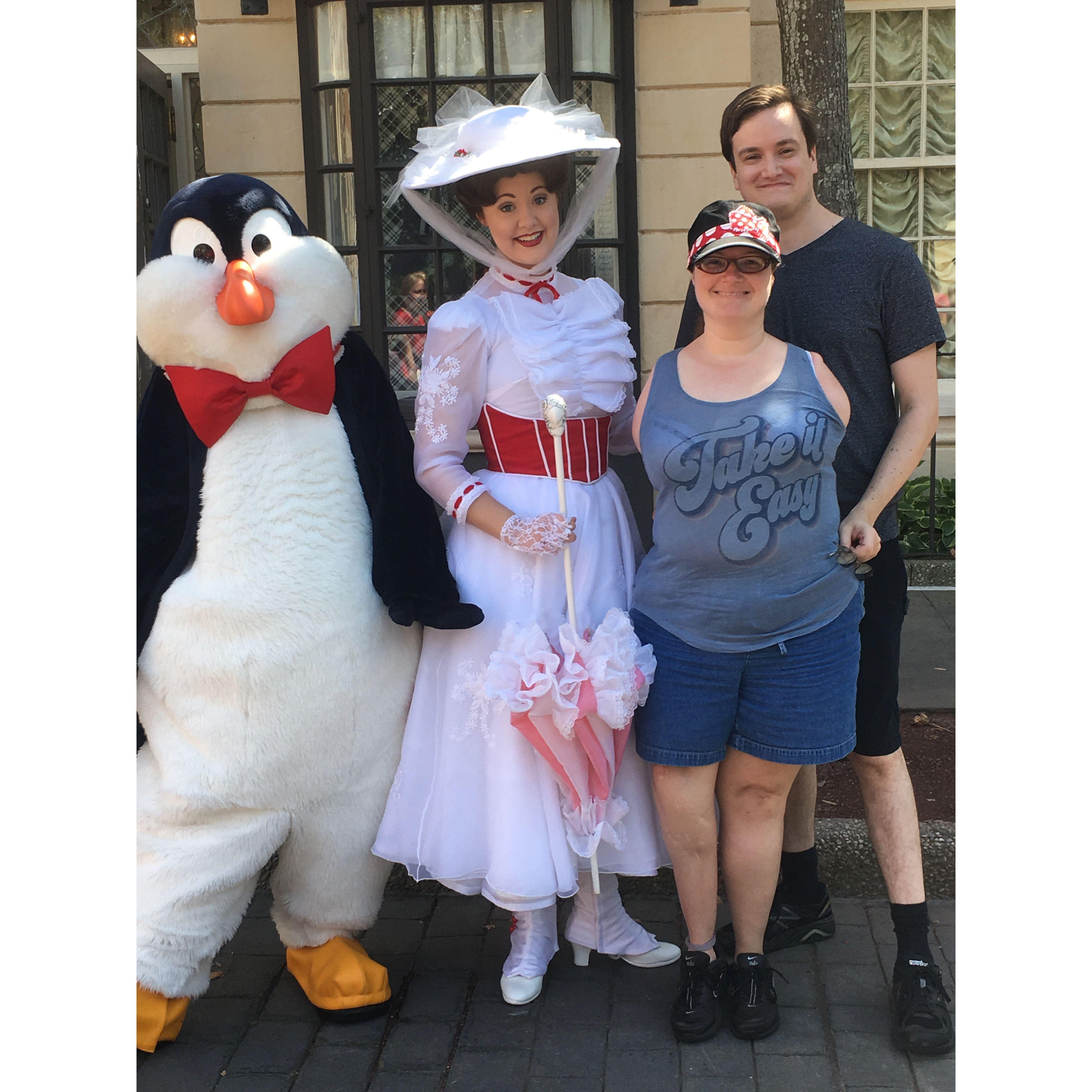 The couple smiles with Mary Poppins and one of the movie’s penguins at Epcot.