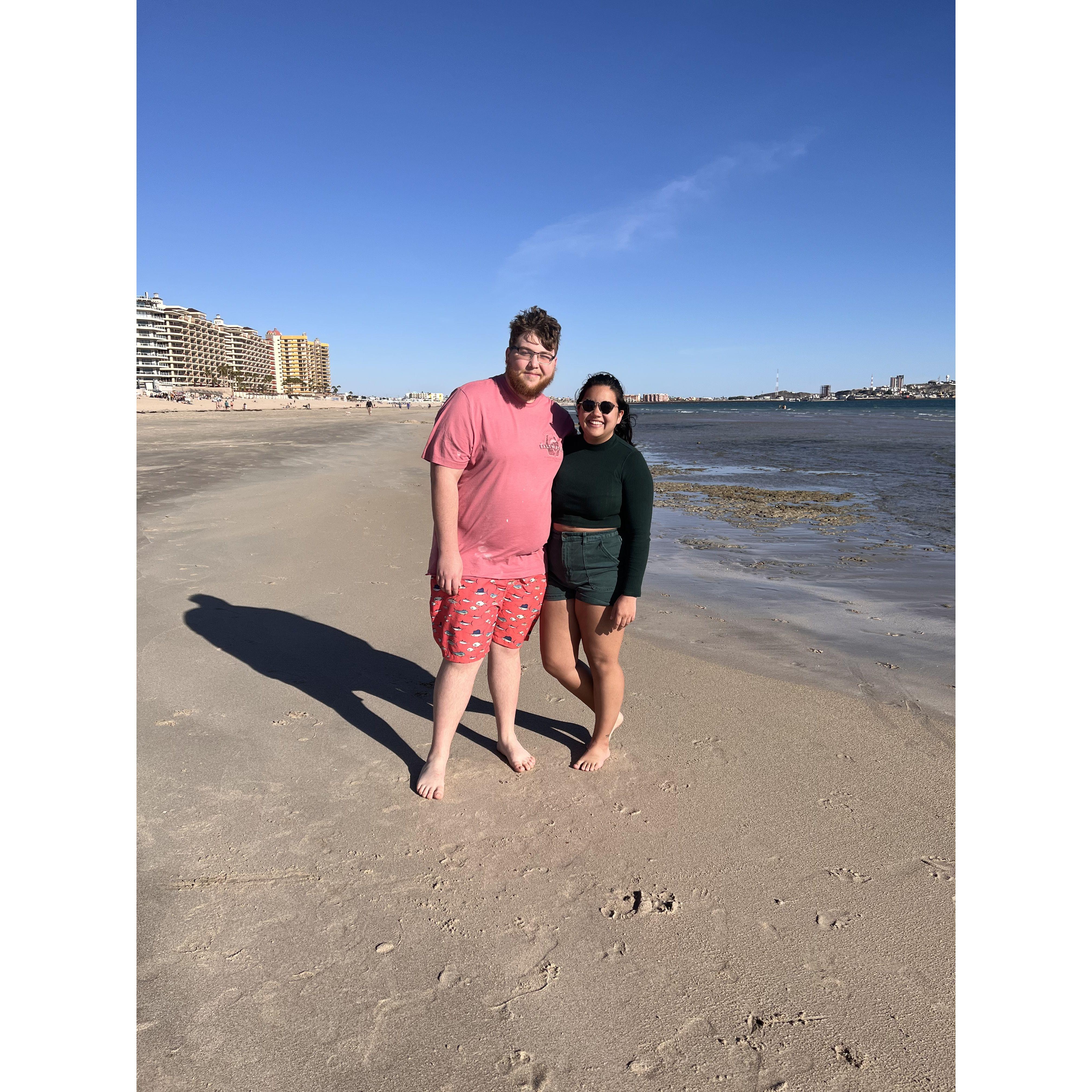 Danny hates sand, but Maya forced him to take beach photos on their spring break trip to Mexico