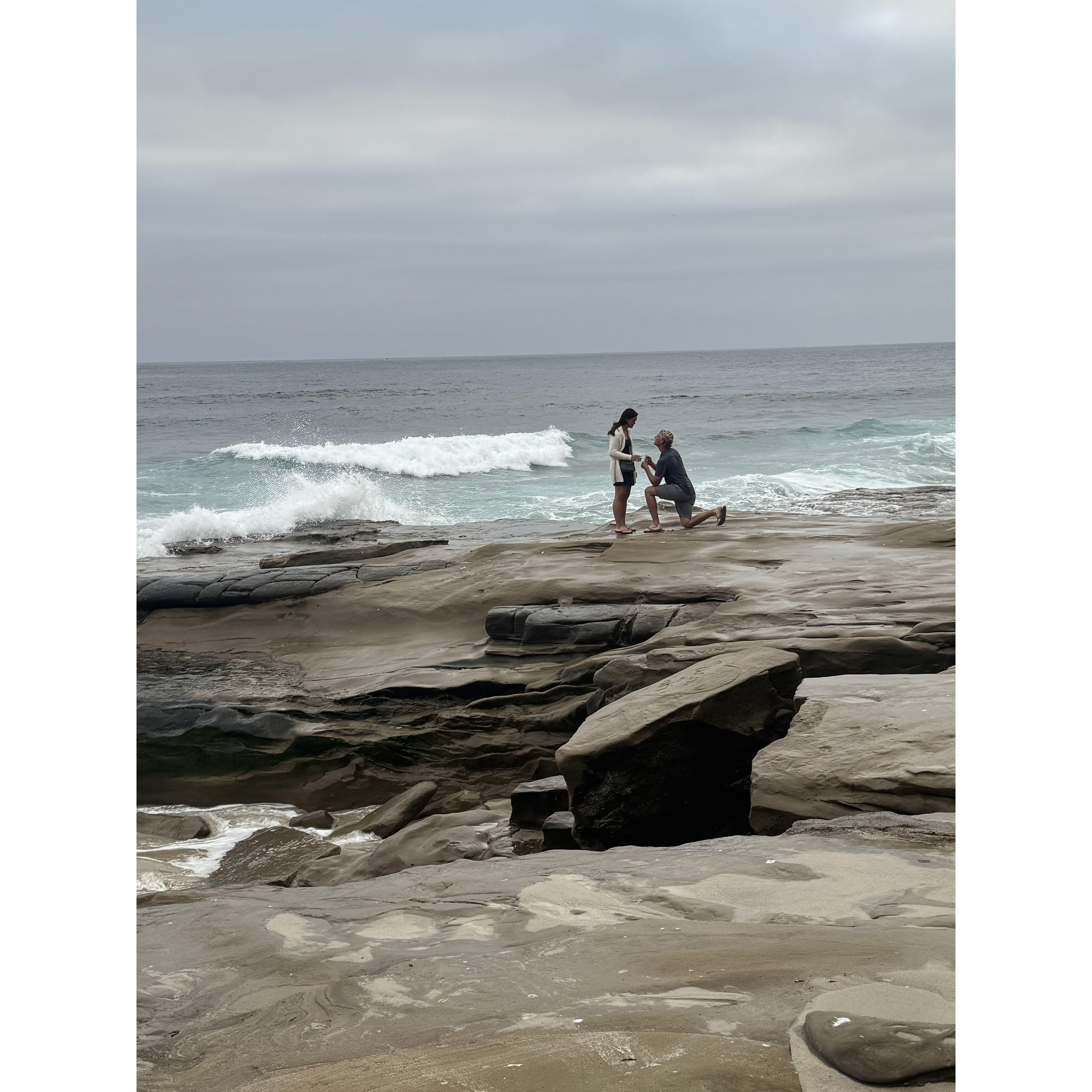 A candid shot from a stranger capturing the moment Wyatt proposed—right at the La Jolla tide pools, where he recreated our first date and the day we first met.