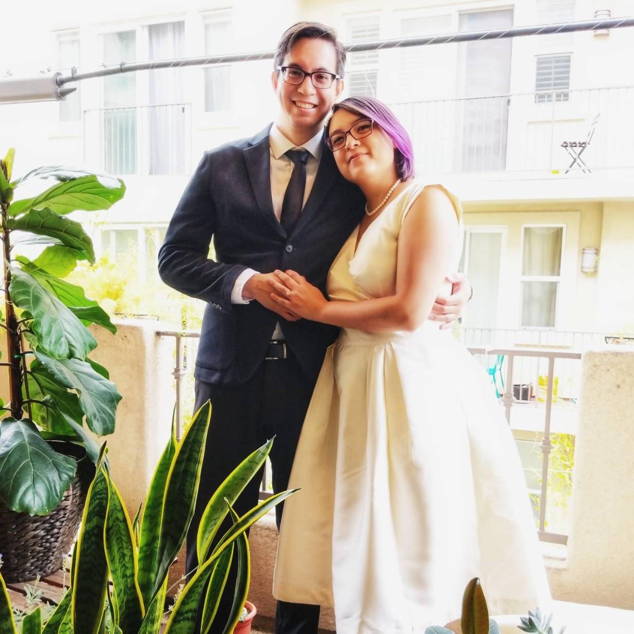 A picture from our pandemic courthouse wedding, taken on our balcony after a zoom call with a judge. The picture was taken as a joke but turned out looking really nice. Brian is not wearing shoes.