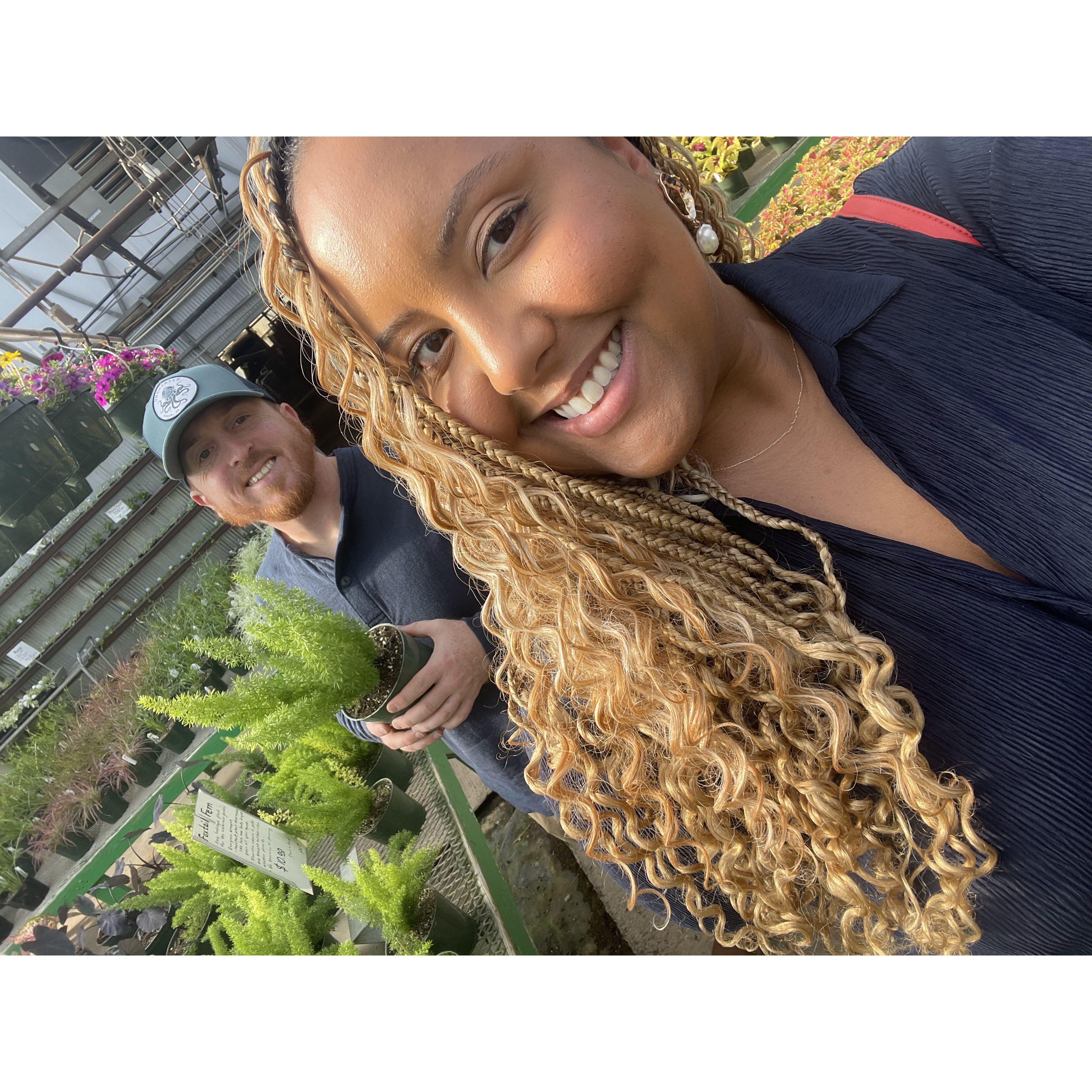 In one of our many "happy places"...at the greenhouse! Where Christina tries to buy too many plants and Sam lovingly reigns her in!
