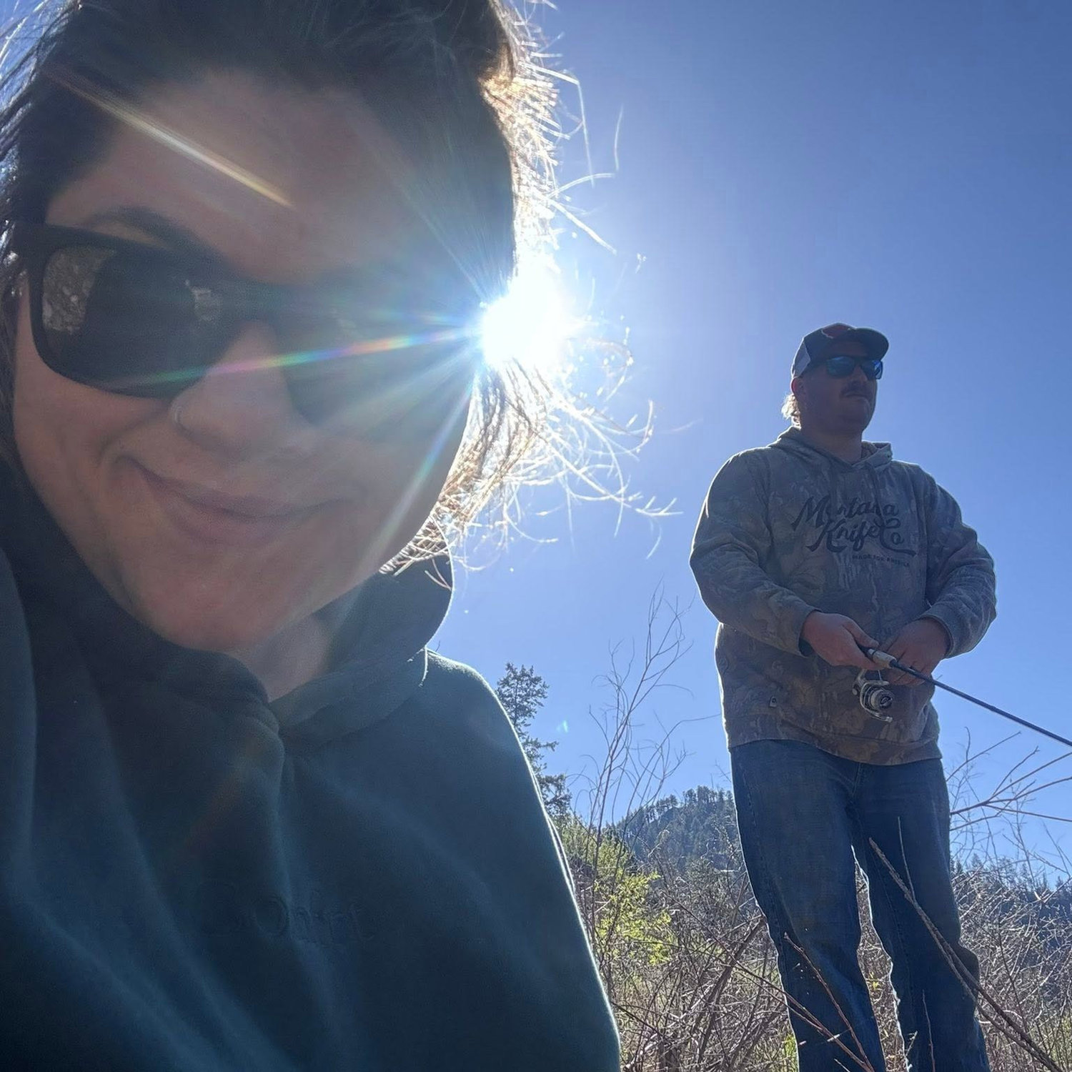 Emily on the ground looking for rocks, and Jesse fishin'