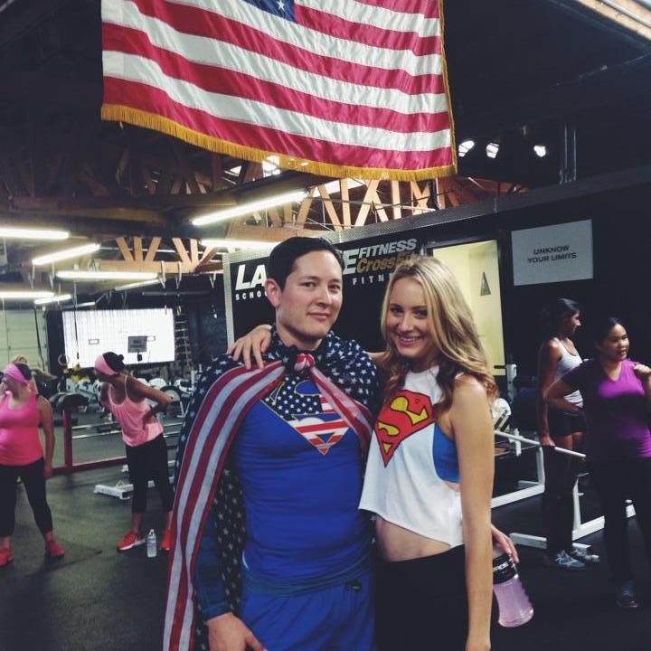 Superwoman cheering on her Superman during a LaLanne Fitness partner WOD