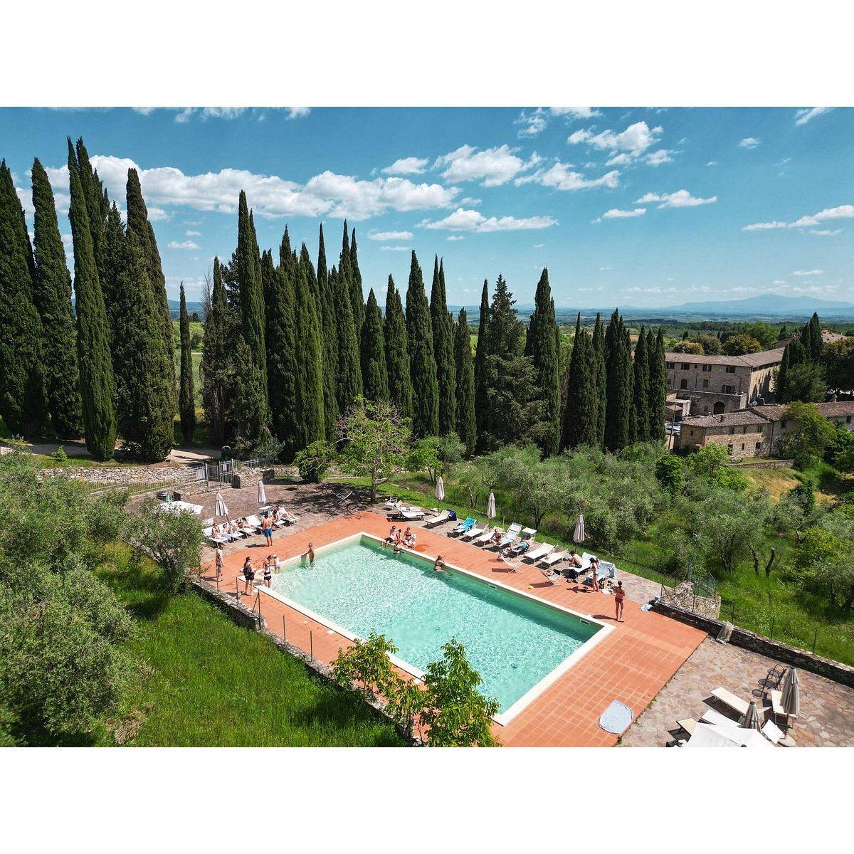 The private pool at Villa Catignano is surrounded by many seating areas including a gazebo for guests to relax.