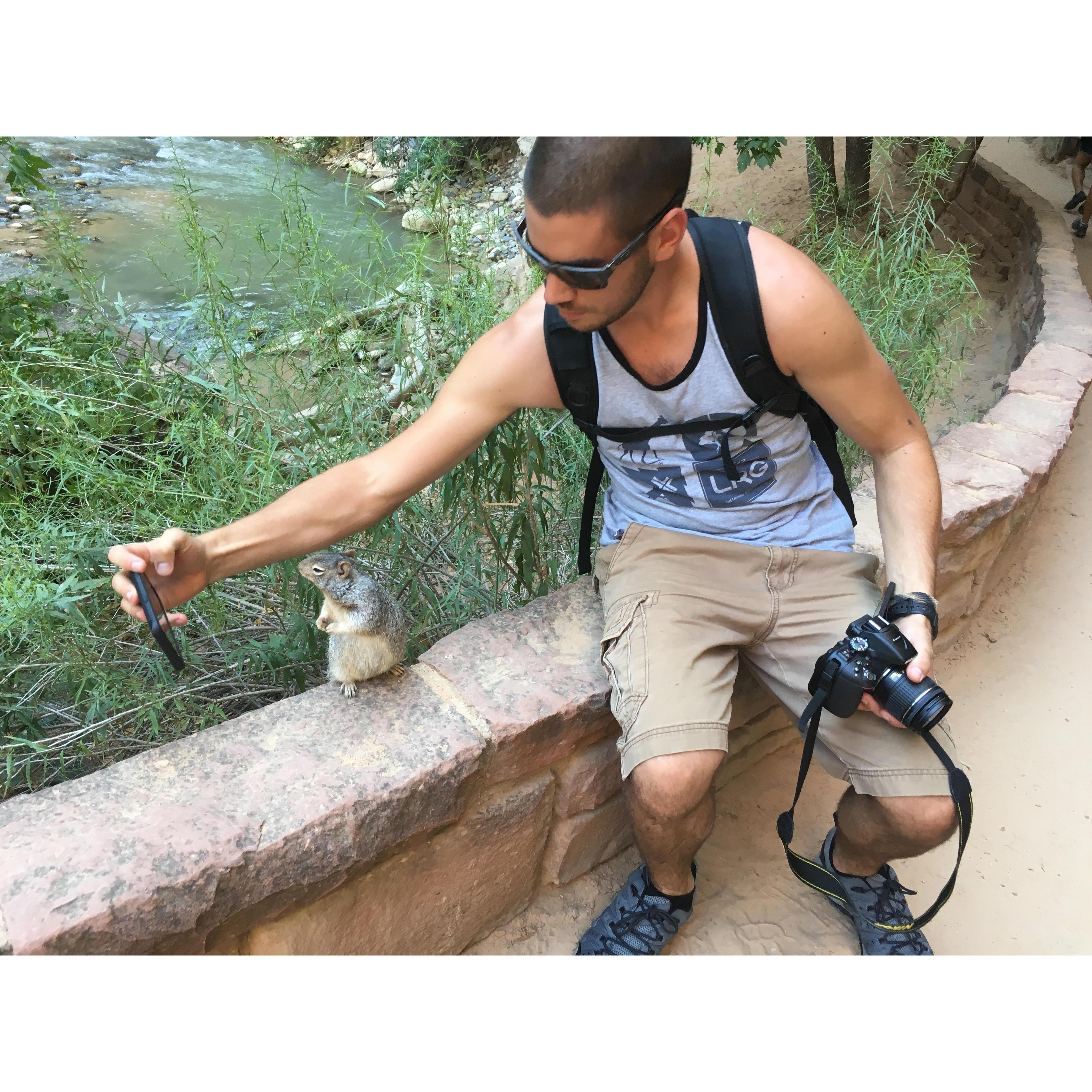 Jared taking a picture with a squirrel in Zion National Park: August 2017