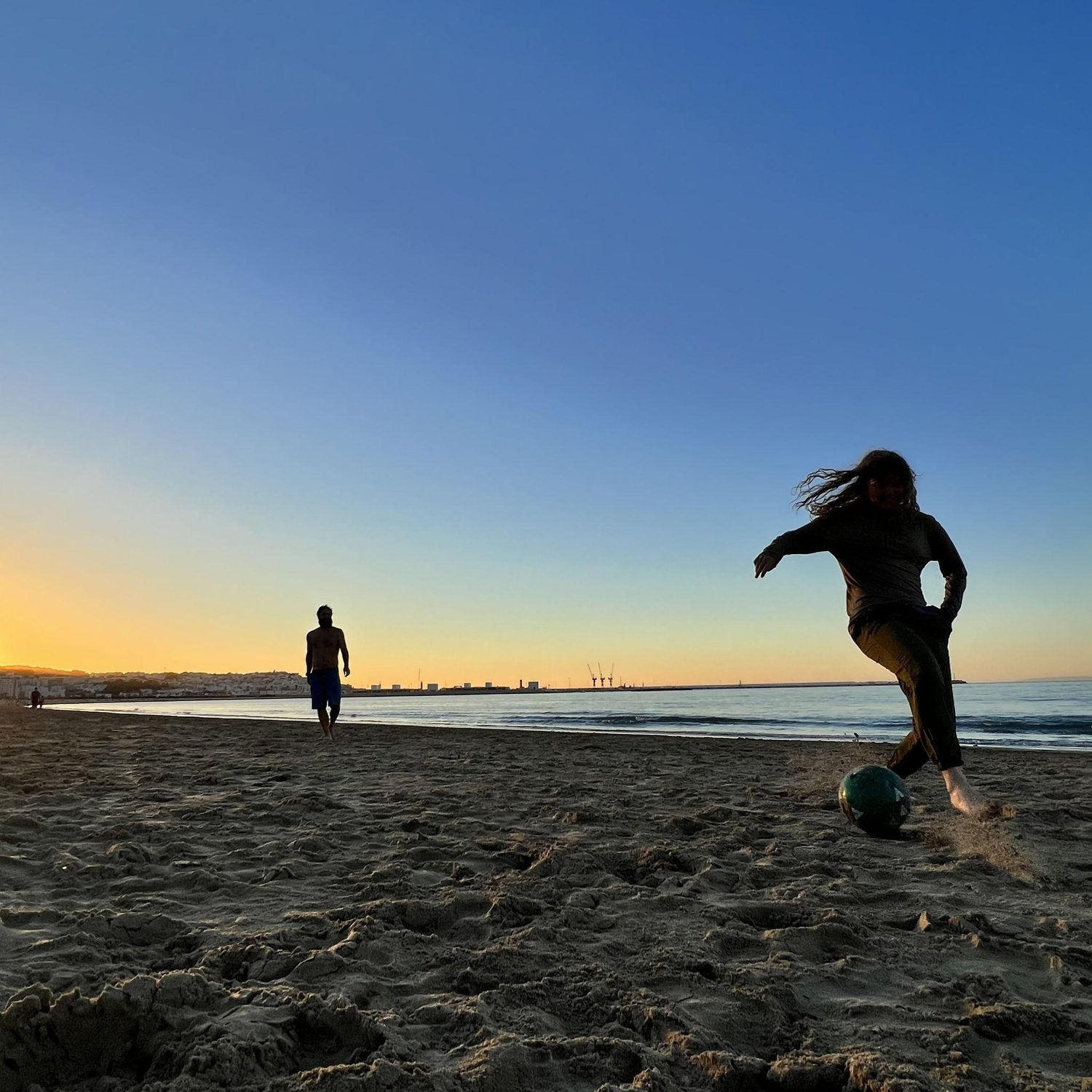 Borrowing a soccer ball from some kids on the beach in Morocco so Jess could show off her skills.