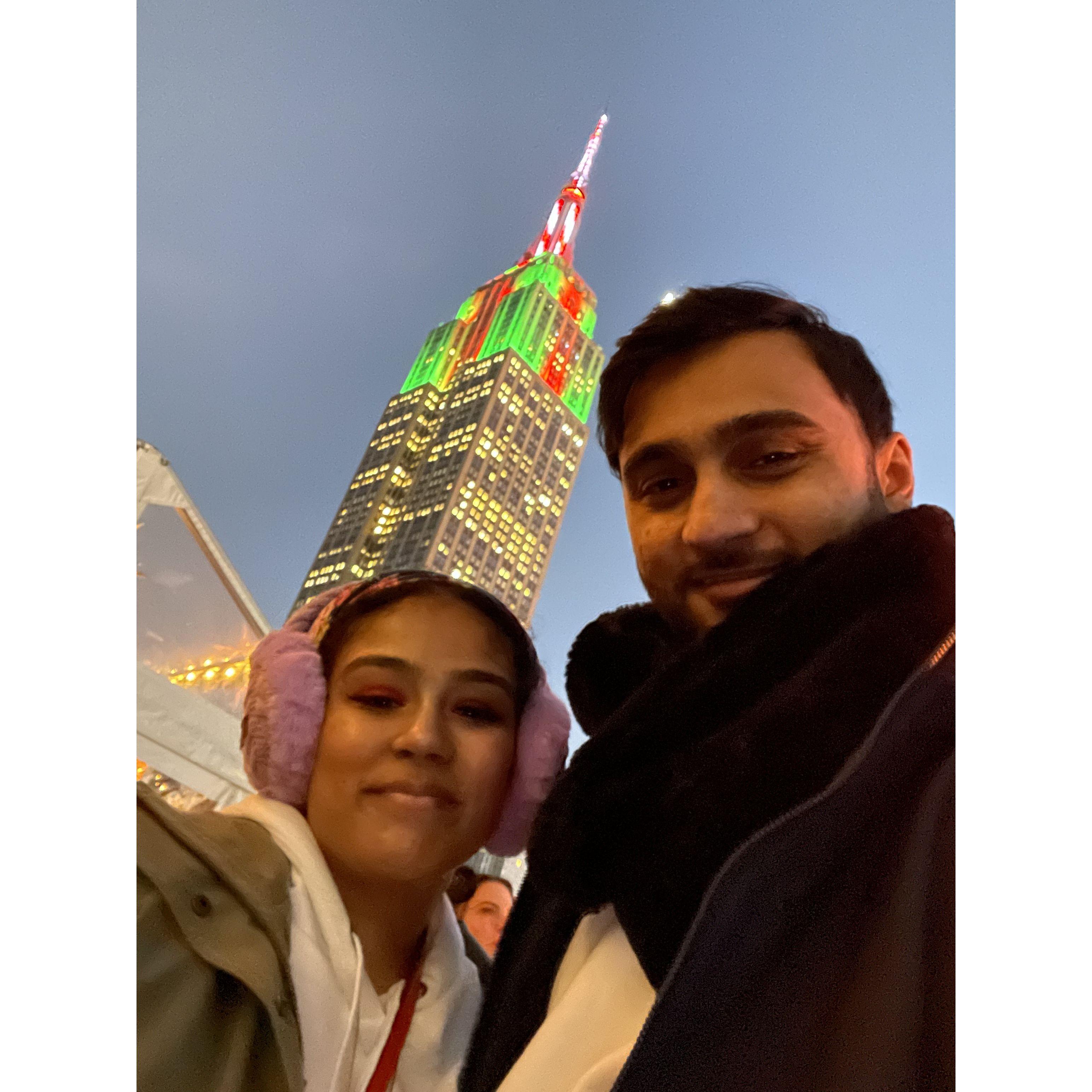 We stand together on a rooftop in New York City, the skyline sparkling beneath us, as the glow of city lights reflects in our eyes, and the cool winter air makes everything feel a little more magical.