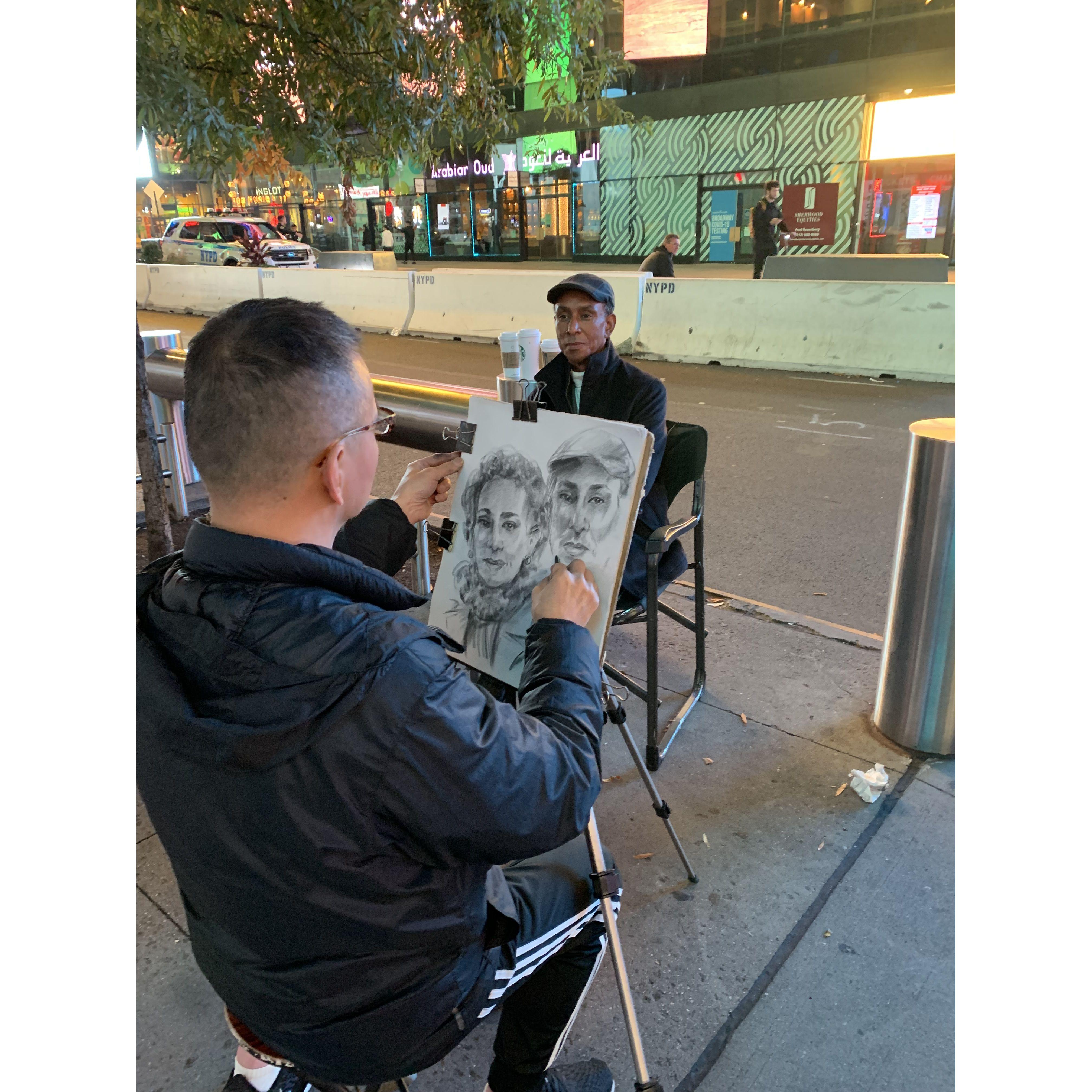 Having our portraits sketched by a talented sidewalk artist in Times Square, NYC.