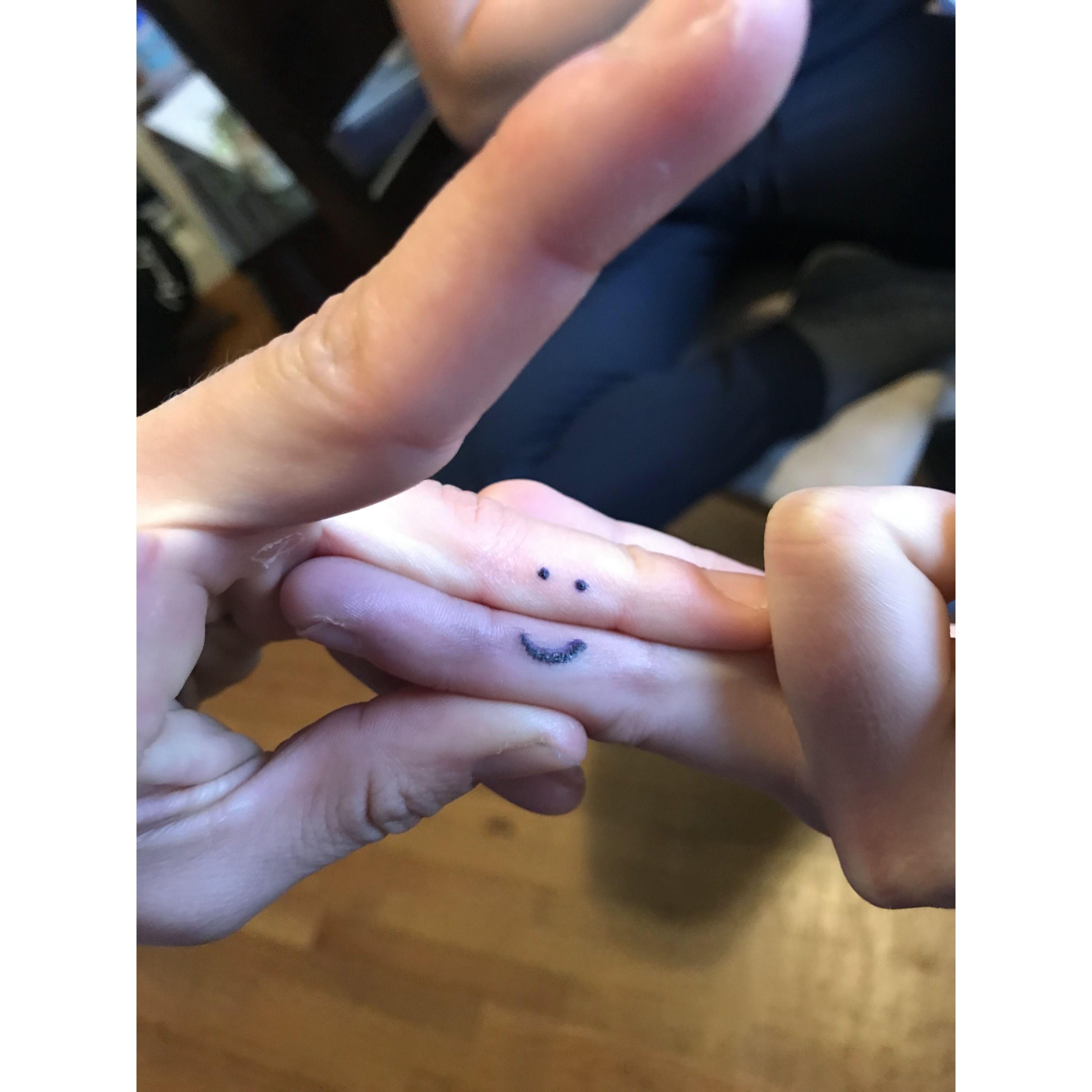 Finney's hand in the eyes, KJ's is the smile. We had one of the players KJ coached stick and poke this on our ring fingers in 2023. This is Finney's first tattoo. We joked that this was our engagement.