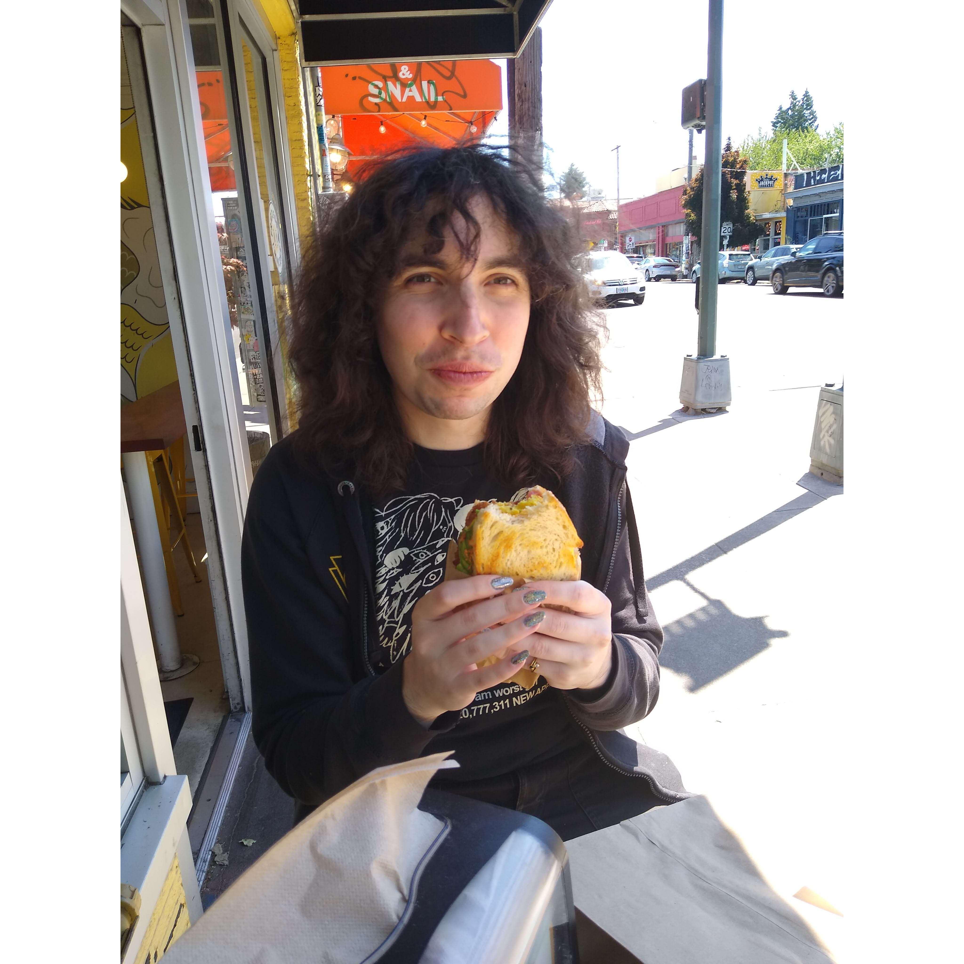 Yara enjoying a delicious vegan breakfast sandwich in Portland