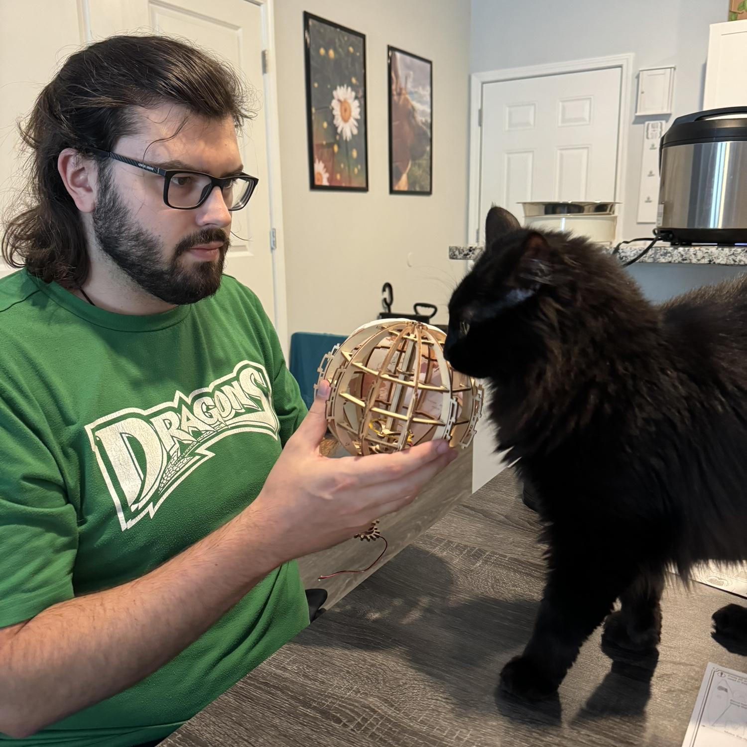 Dalton building a wooden globe with his cat, Jager, June 2024