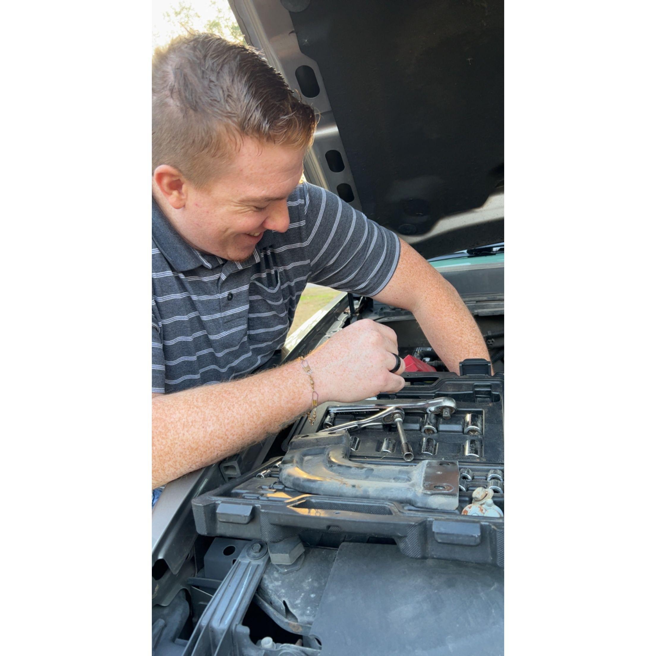 Charles putting a new battery in Jerrika's car! (He's so sweet)