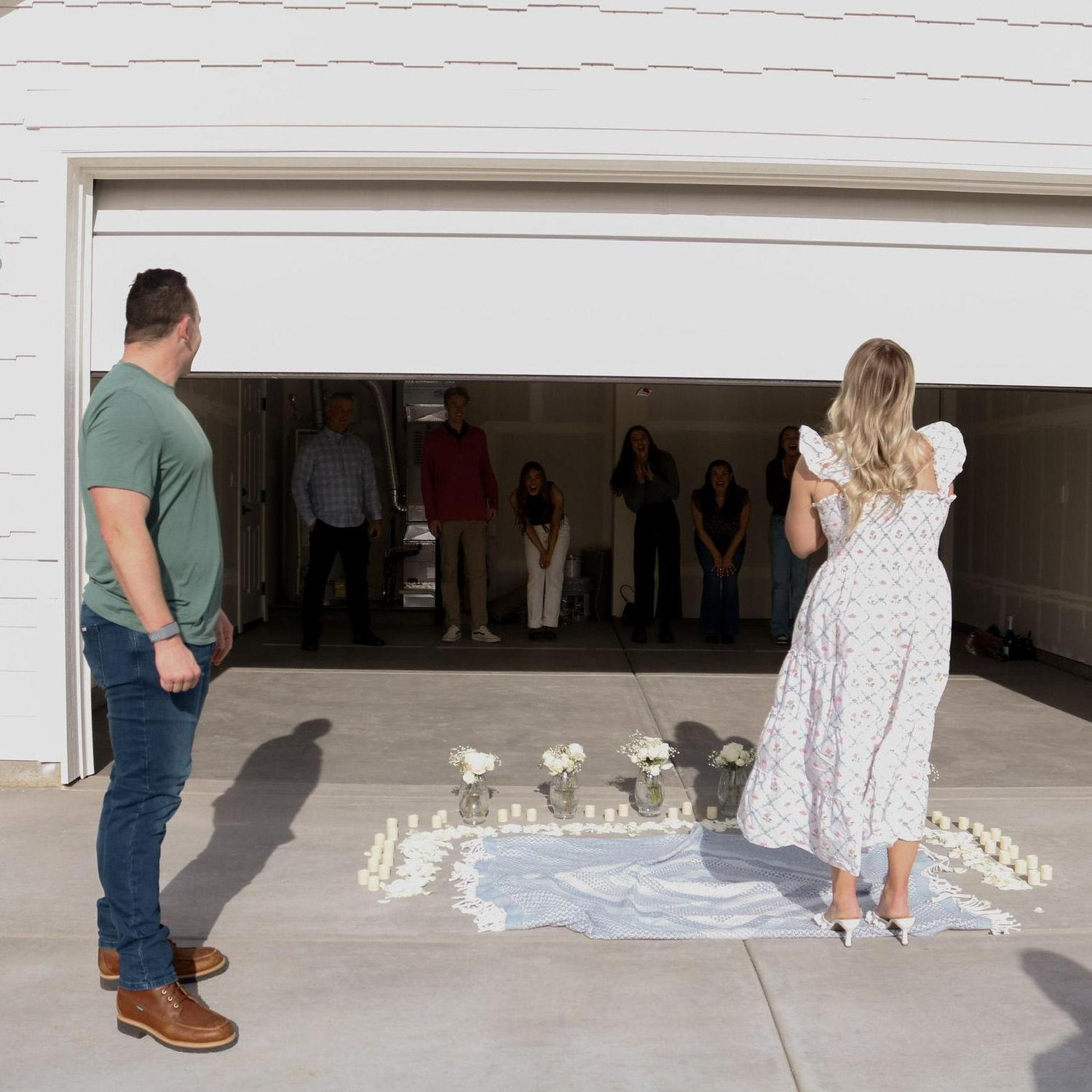 He then surprised her with their families waiting in the garage!