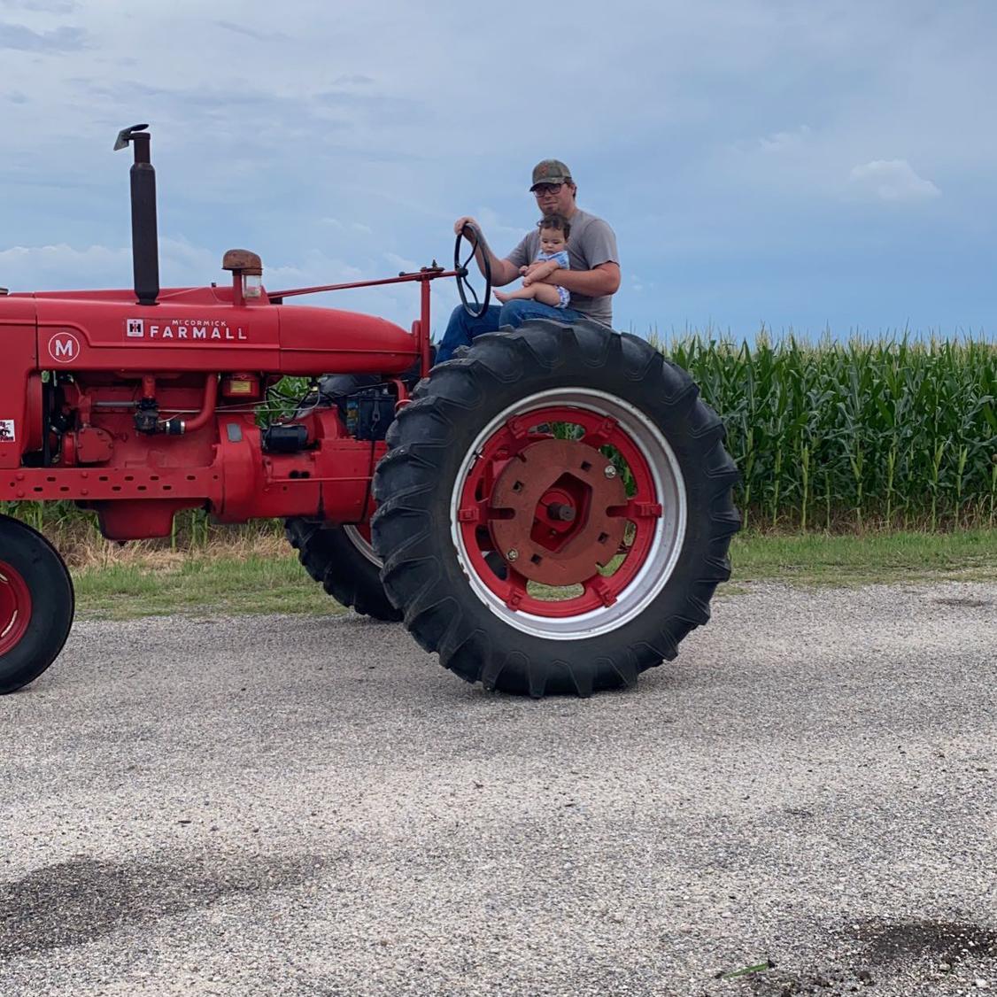 Baby girls first tractor ride with daddy