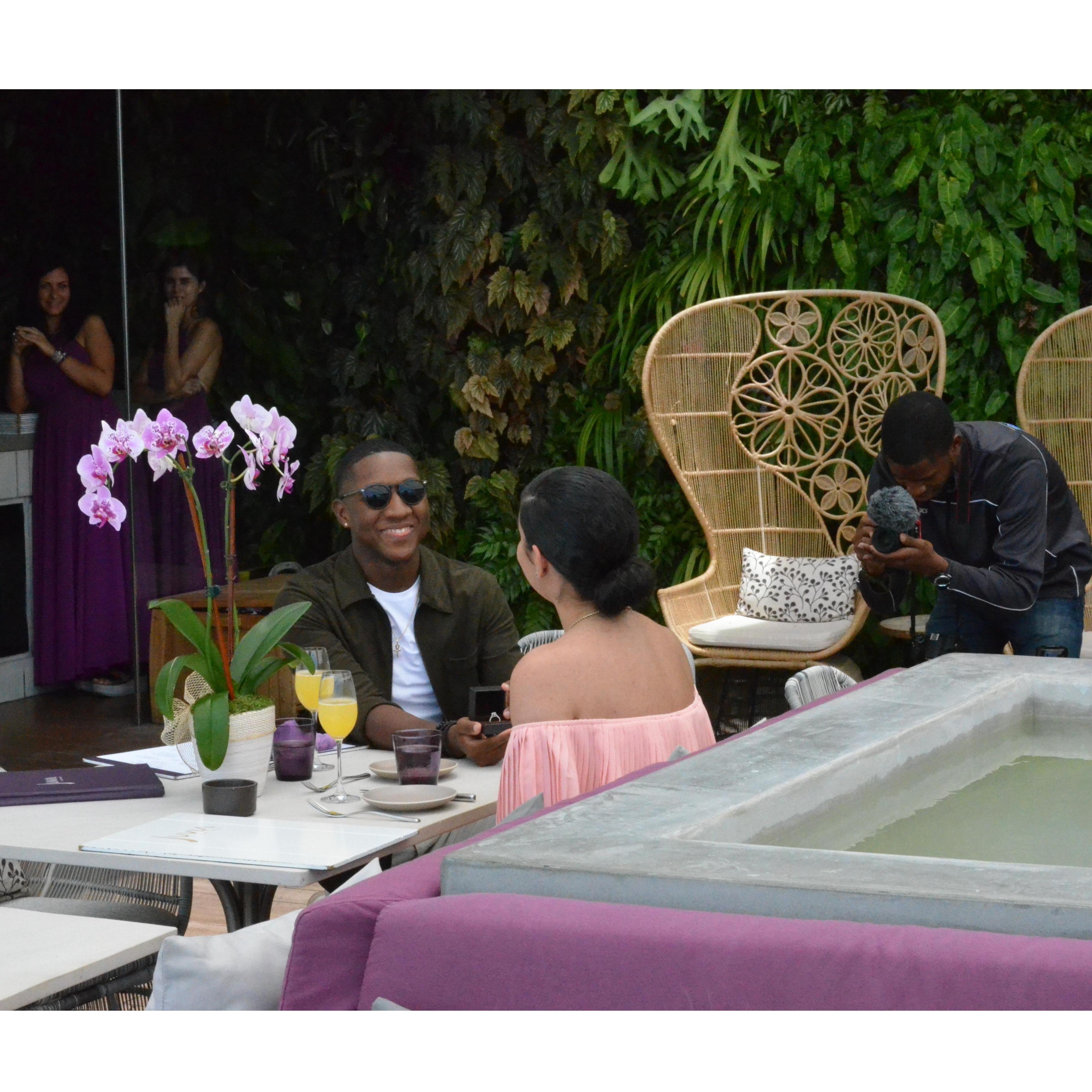 Joshua shows Amanda the ring. And aww man is that a videographer to her right! The hostesses in the back are all smiles. The whole restaurant knew all along!