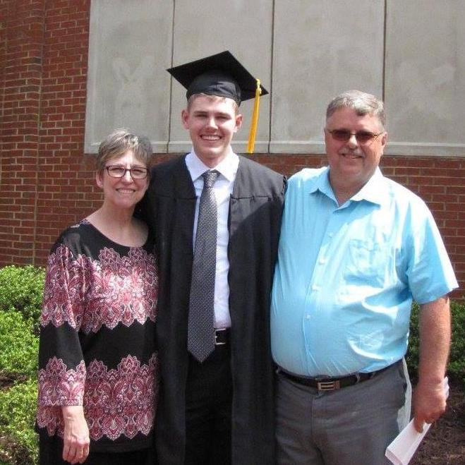 Casey enjoying his graduation day with his parents by his side.