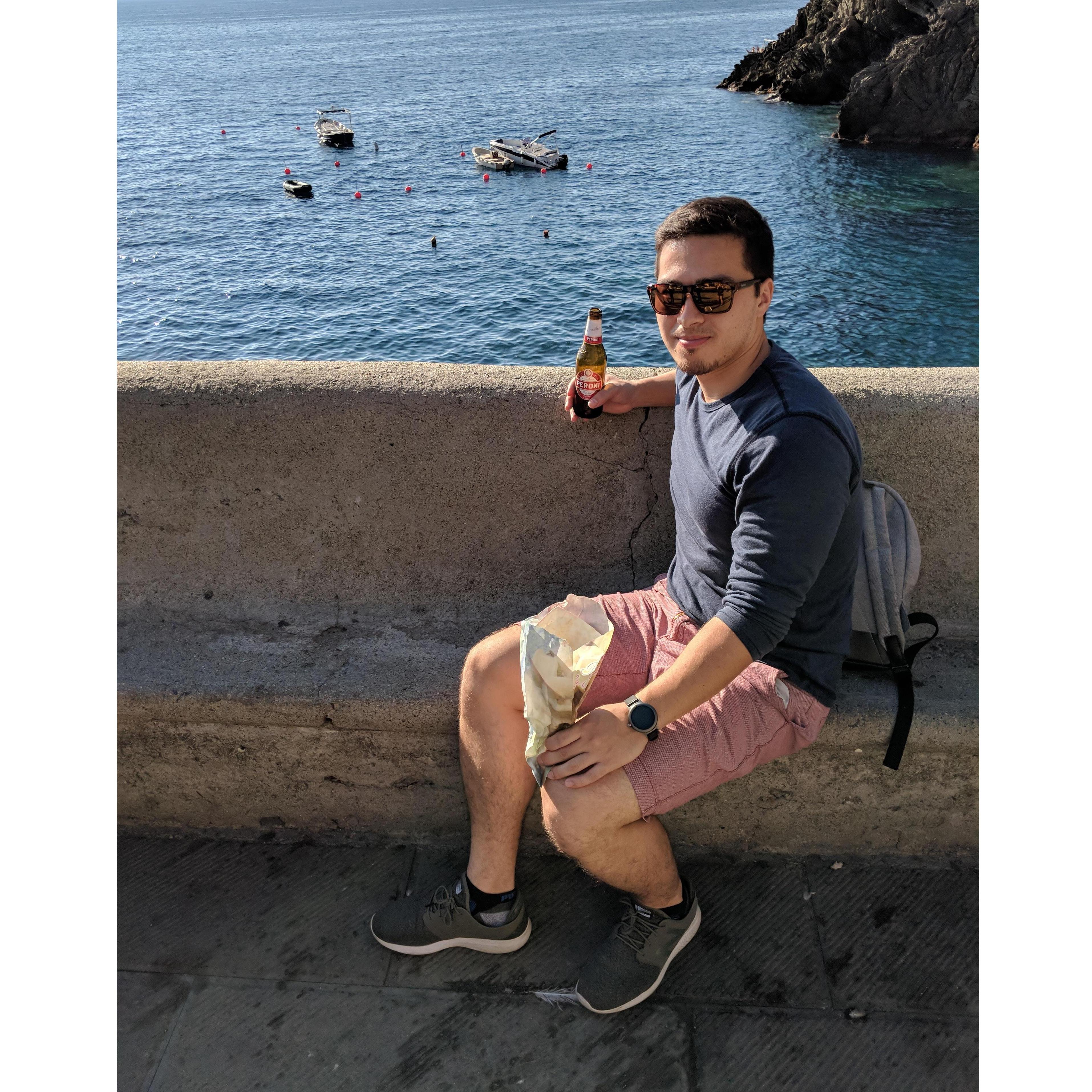 Nik enjoying a beer and fried cone of seafood in Manarola, Italy where he proposed