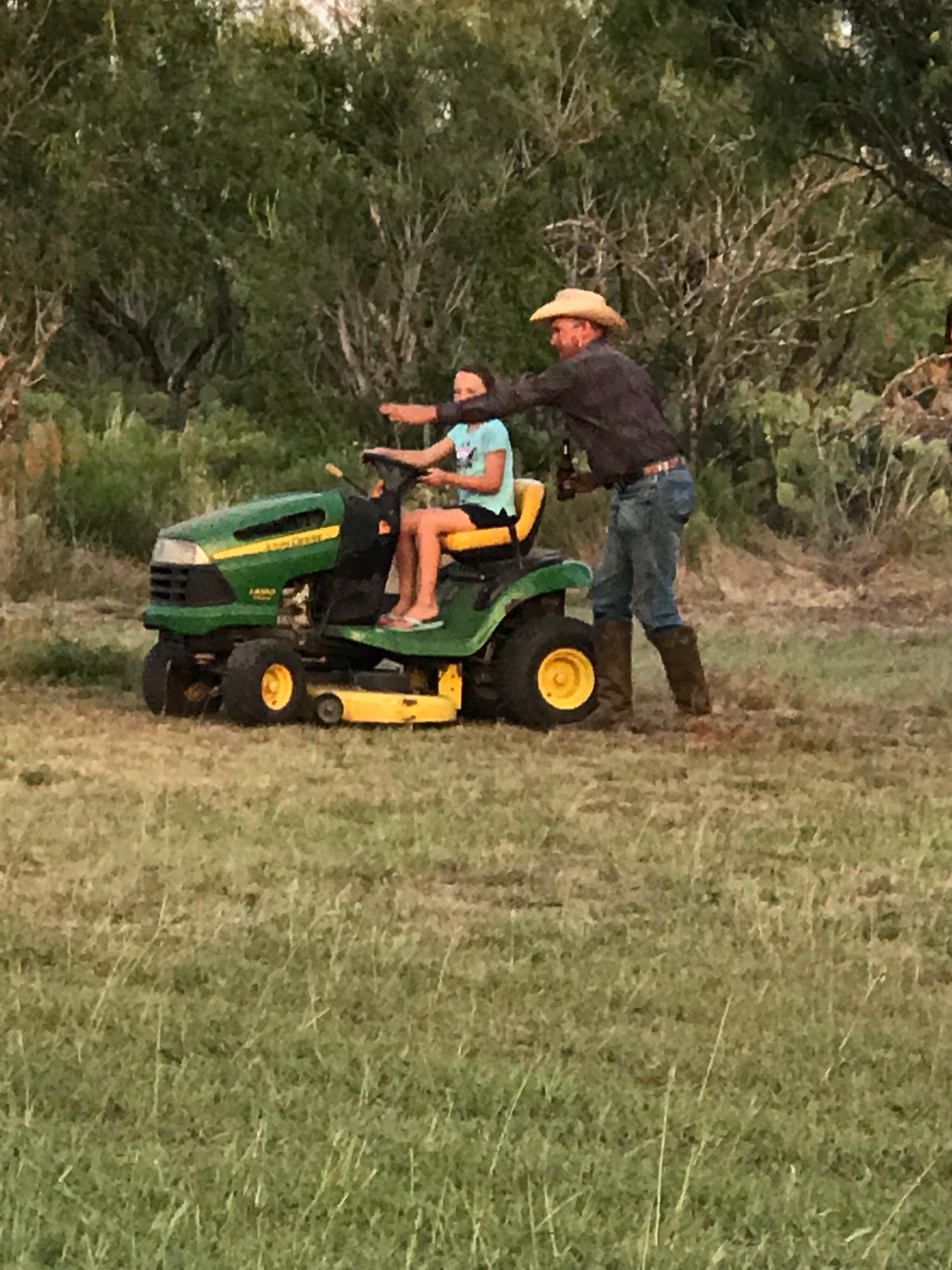 TJ teaching Madison to drive the lawnmower