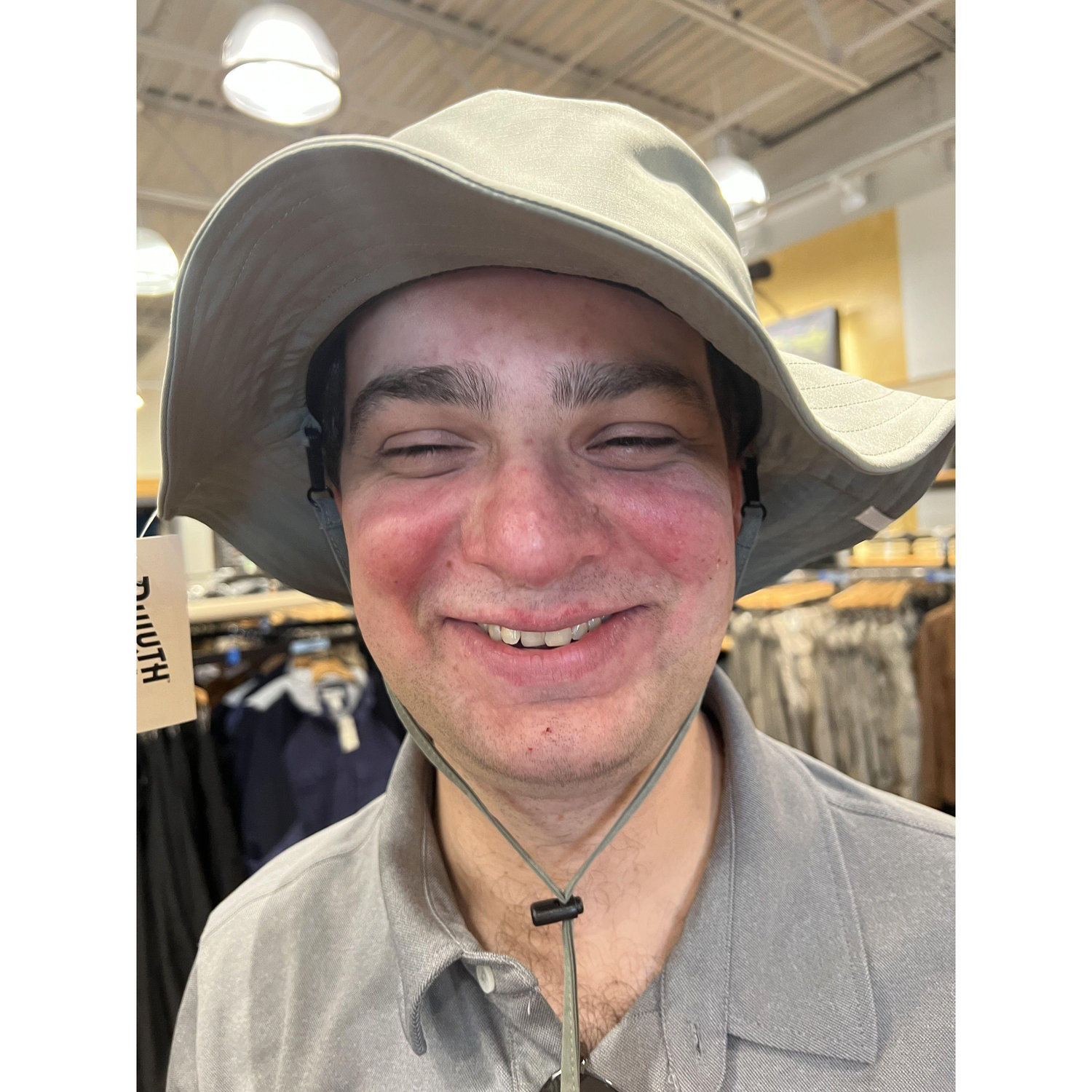 Alex trying on hats while on vacation